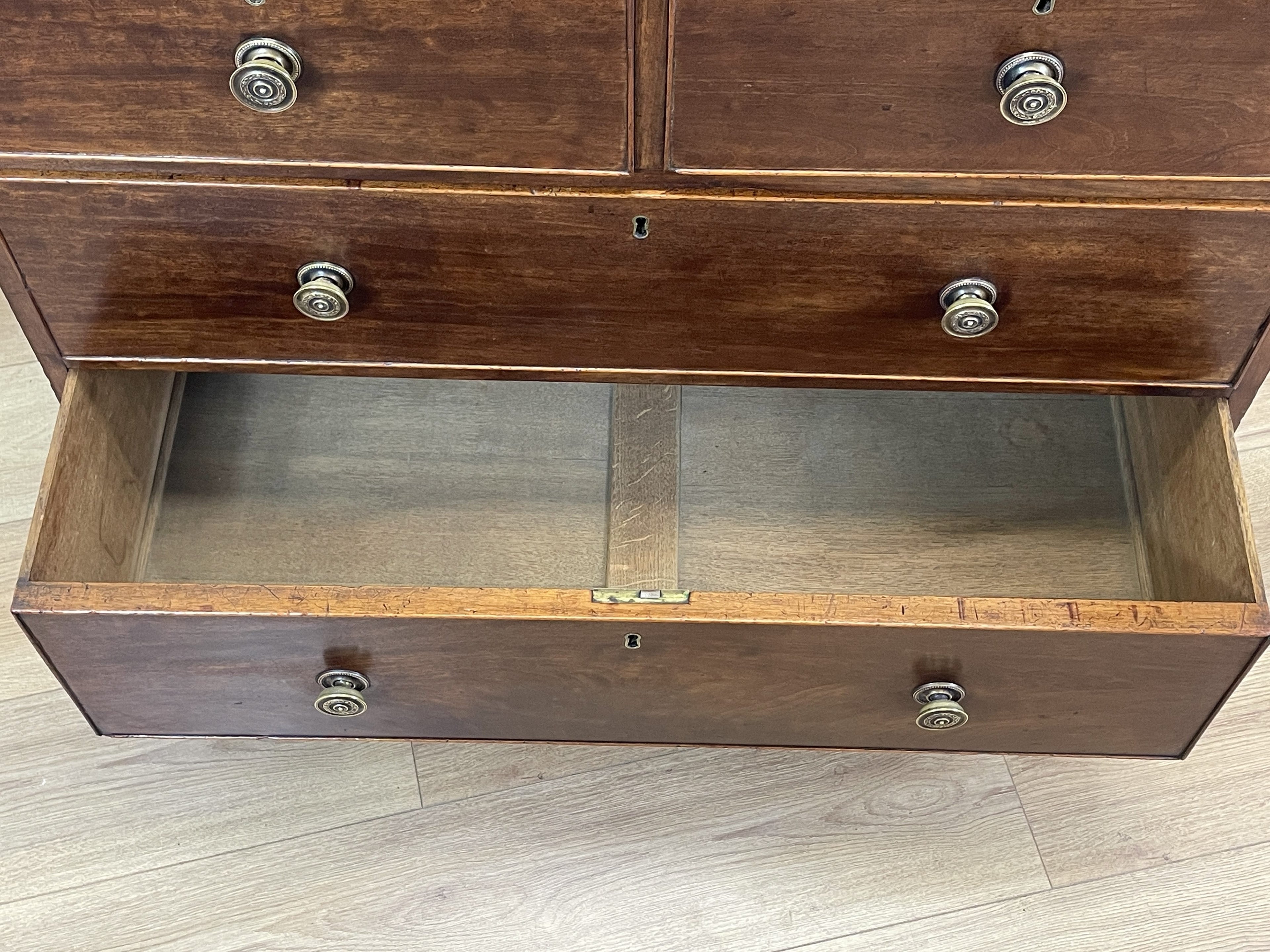 Wooden display cabinet with glass front on a wooden floor