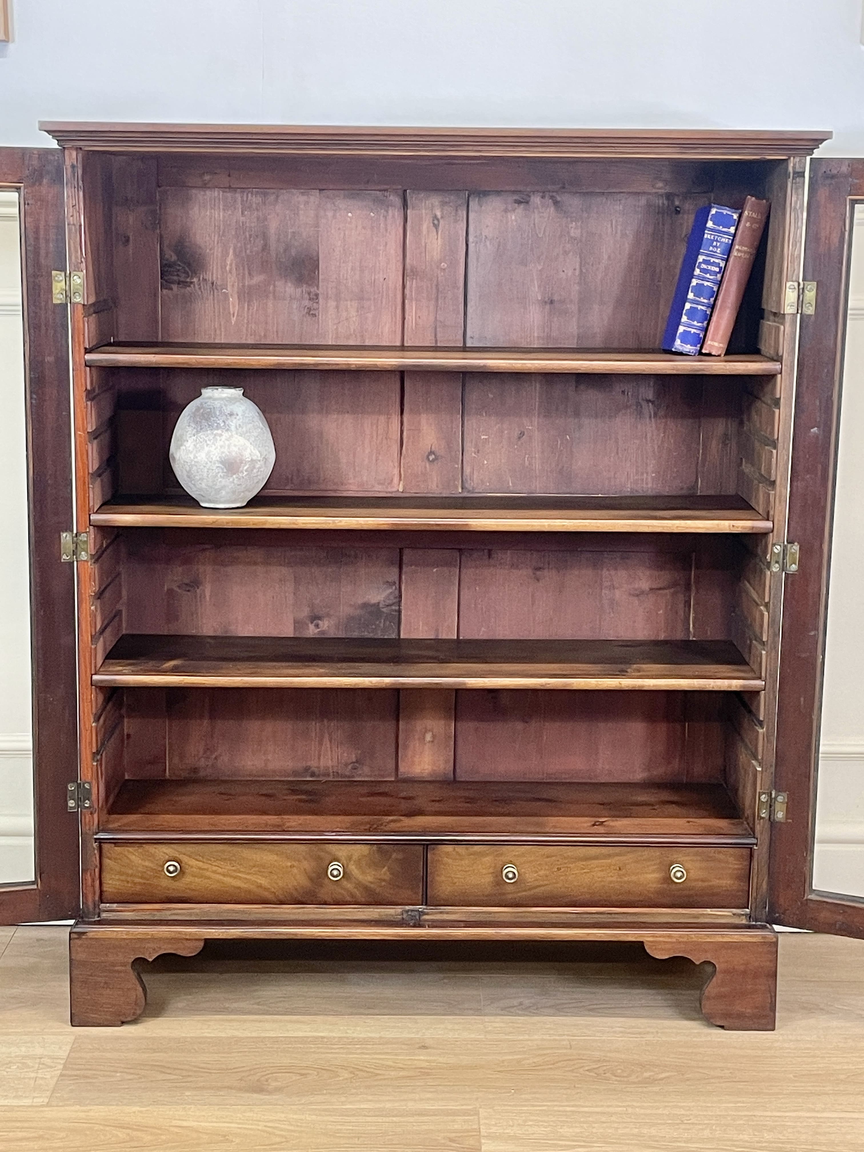 Wooden bookshelf with decorative items on a wooden floor
