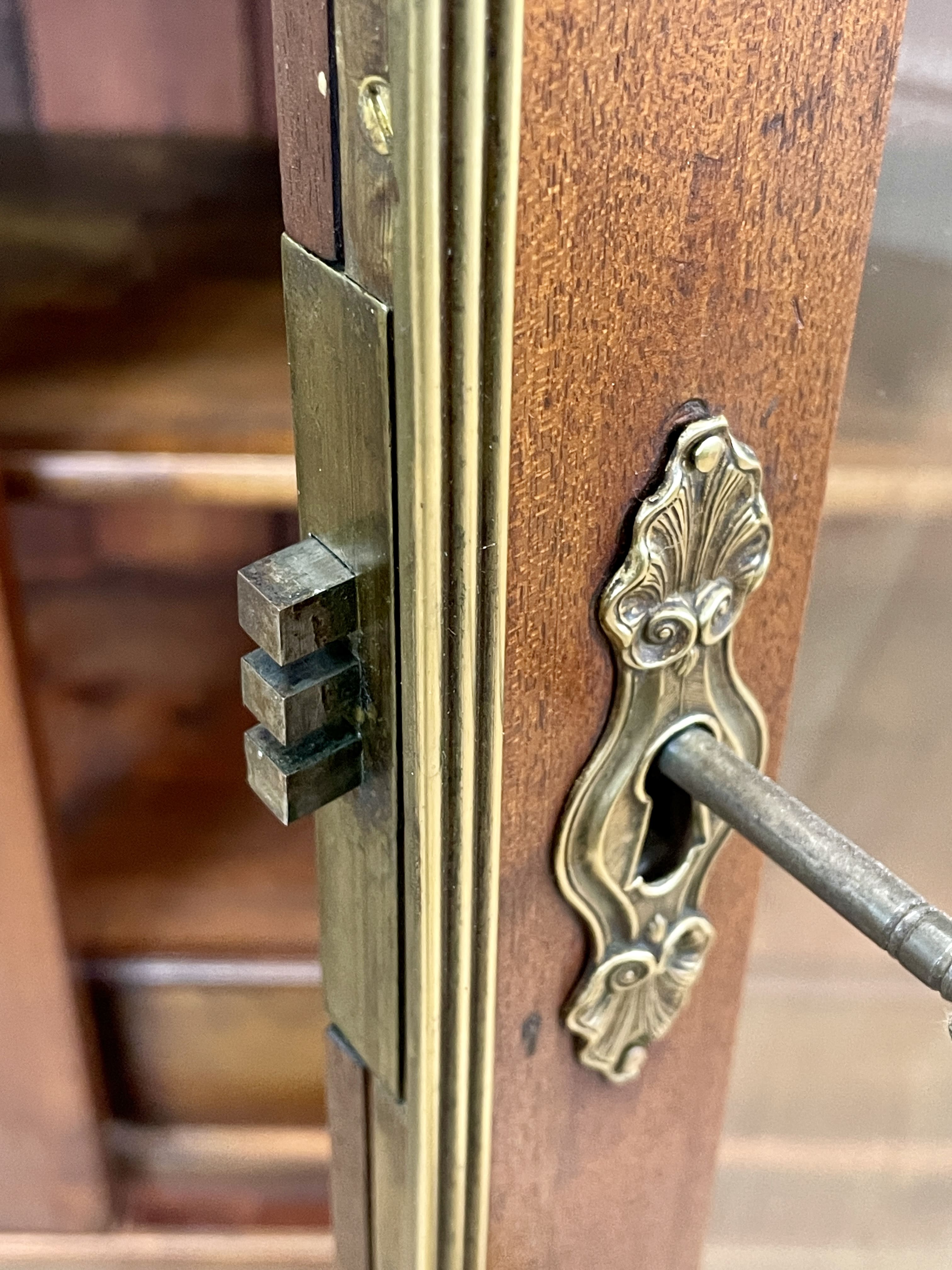 Close-up of a wooden door with a brass handle and lock mechanism.