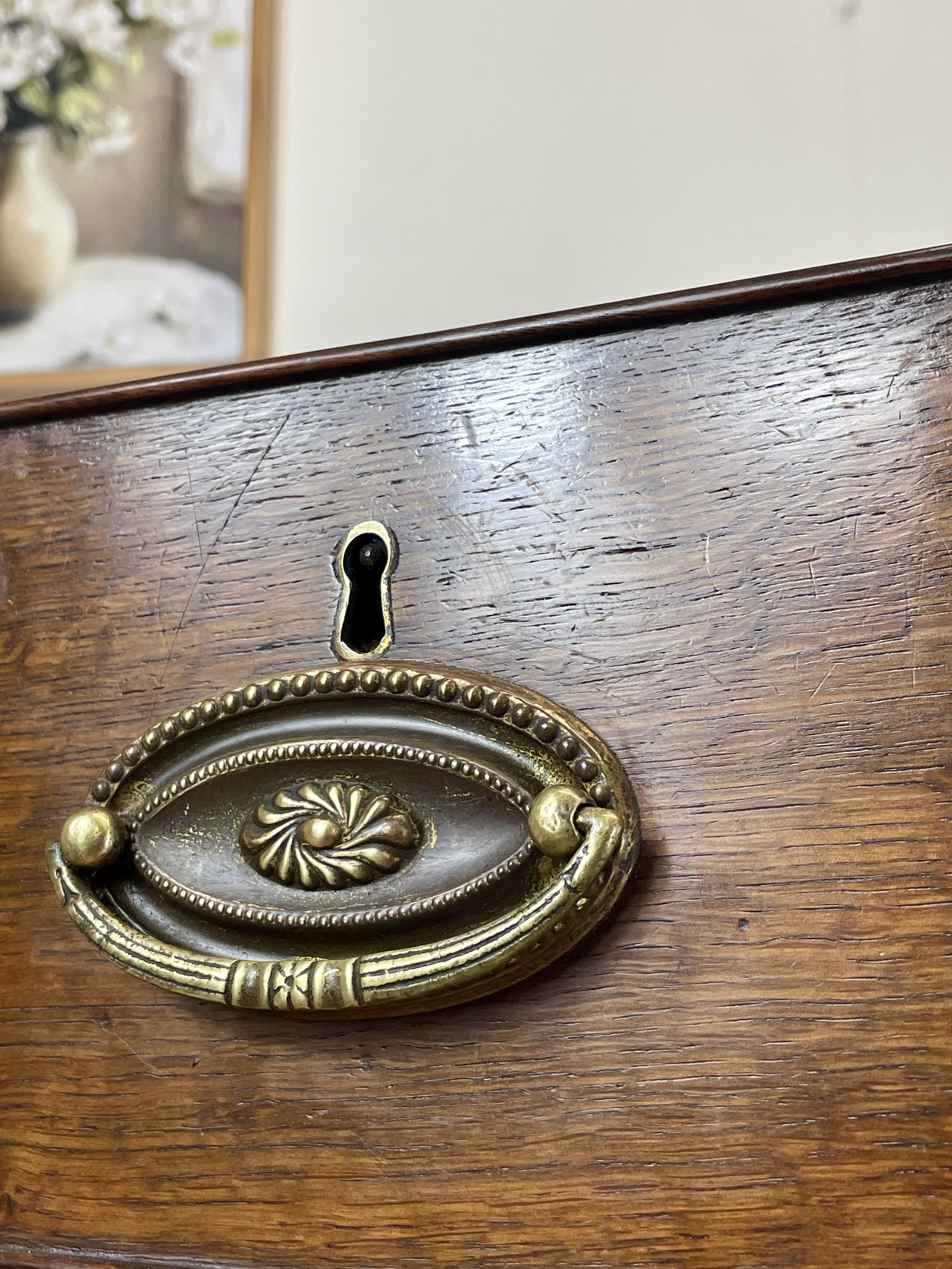 Decorative brass handle on a wooden surface
