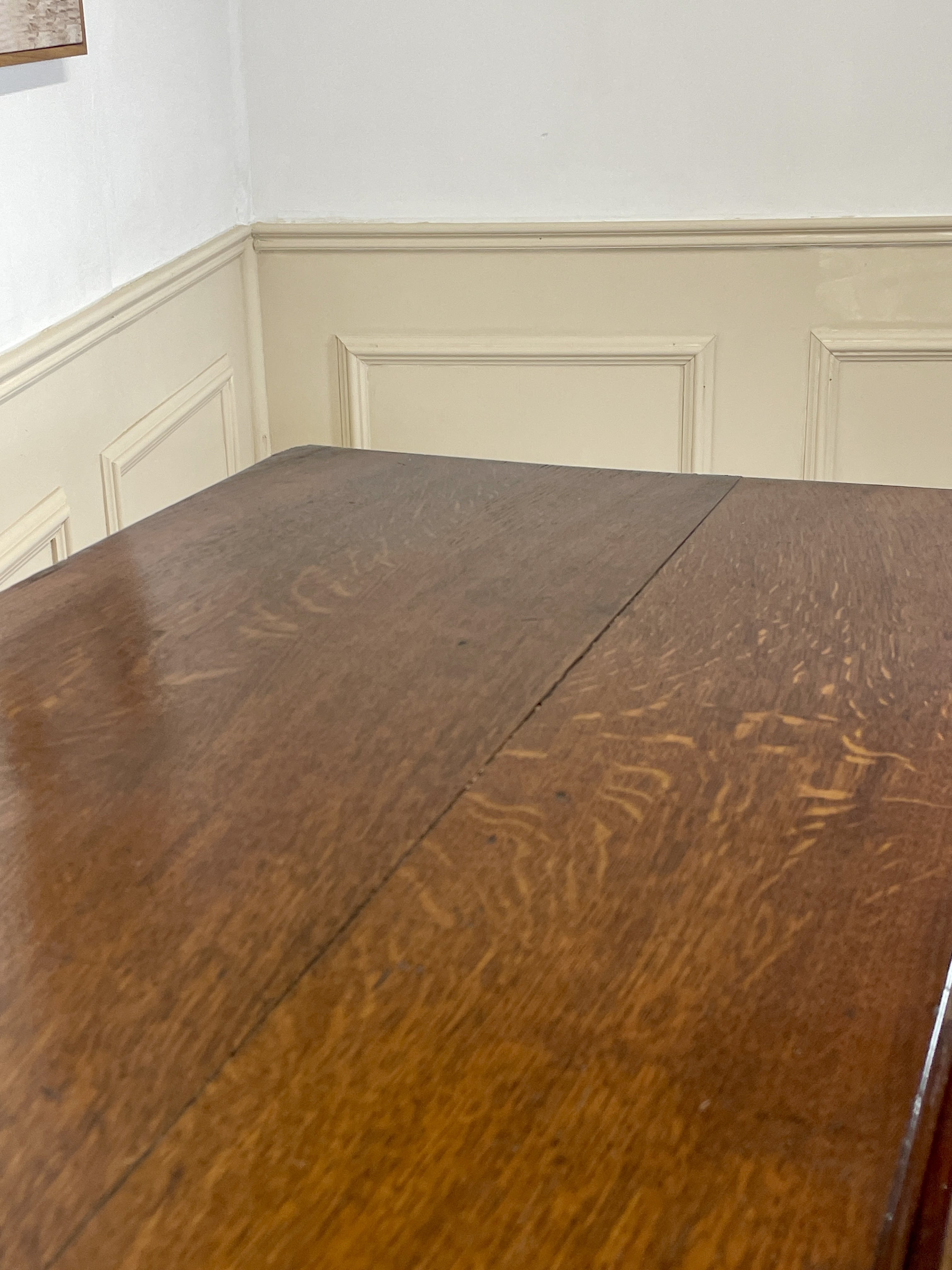 Wooden table with wainscoting in the background