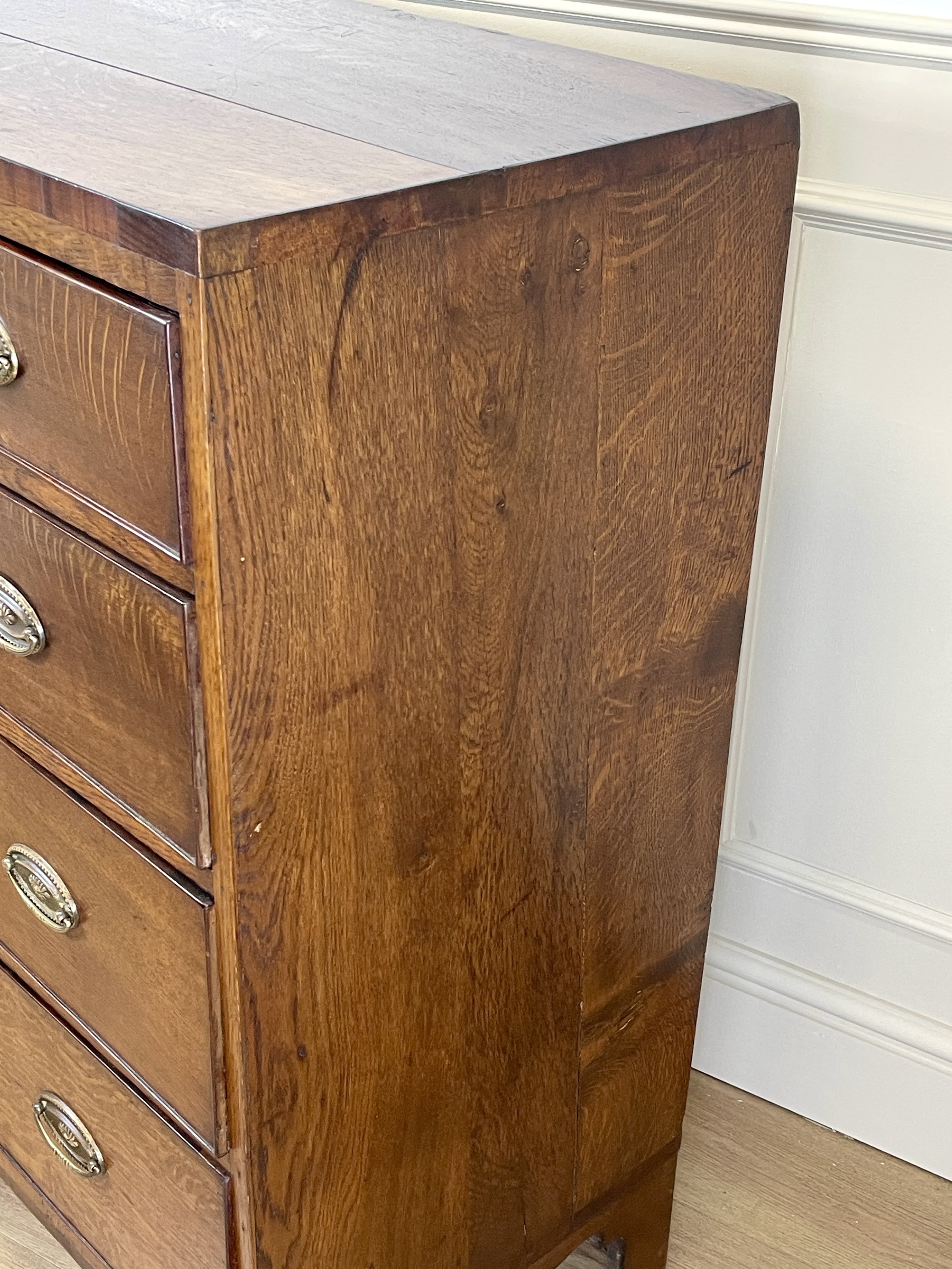 Wooden dresser with drawers against a white wall.