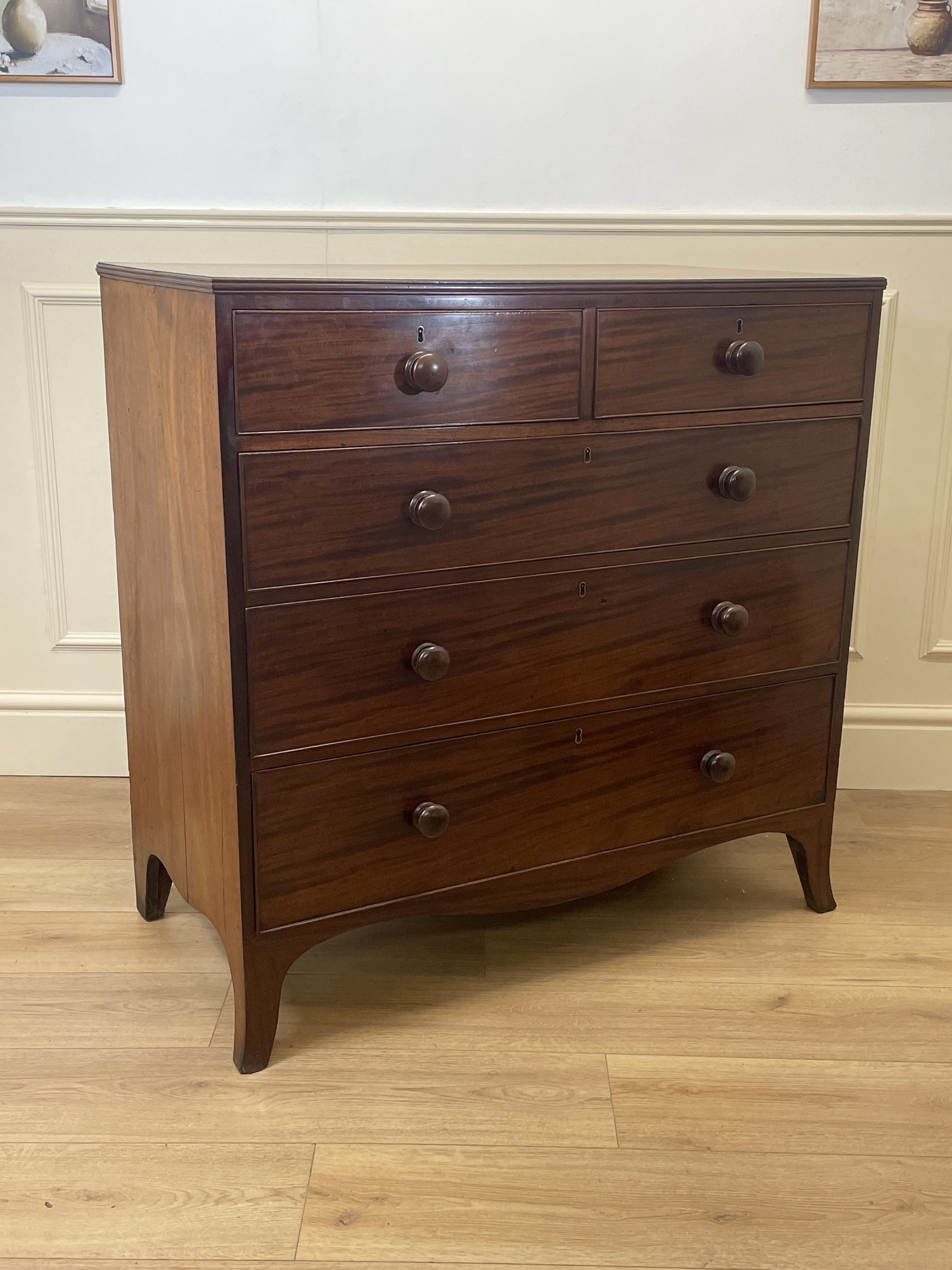 Wooden dresser with multiple drawers on a wooden floor.
