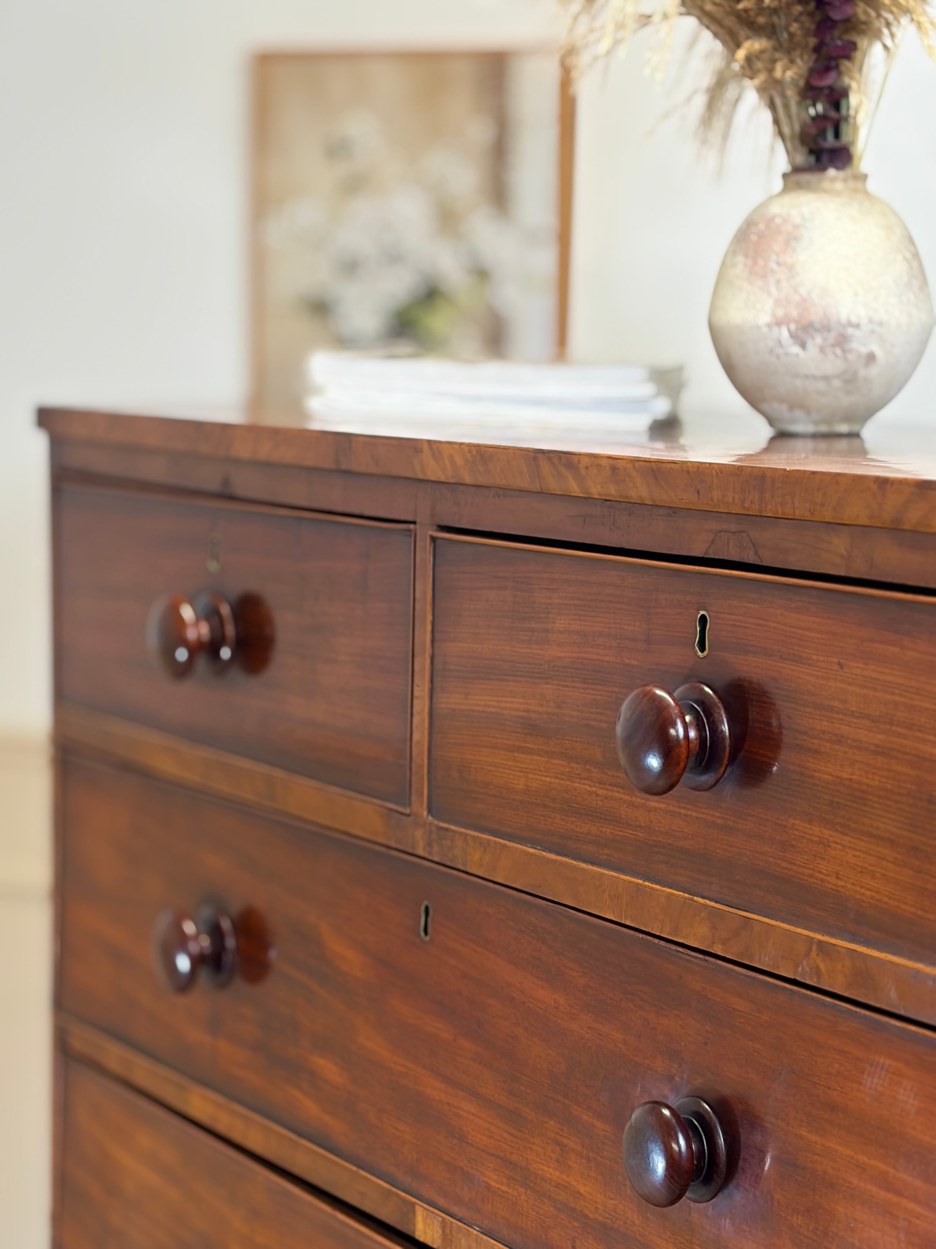 Wooden dresser with four drawers and decorative items on top