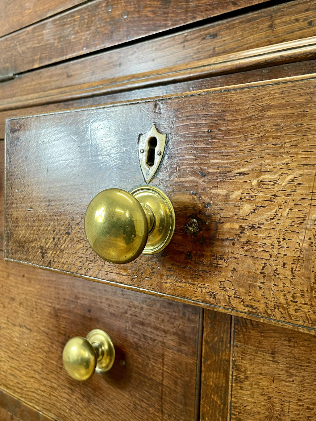 Close-up of a wooden door with brass doorknobs and a keyhole.
