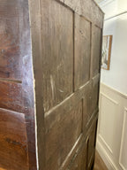 Close-up of a wooden wardrobe with a white wall and framed picture in the background