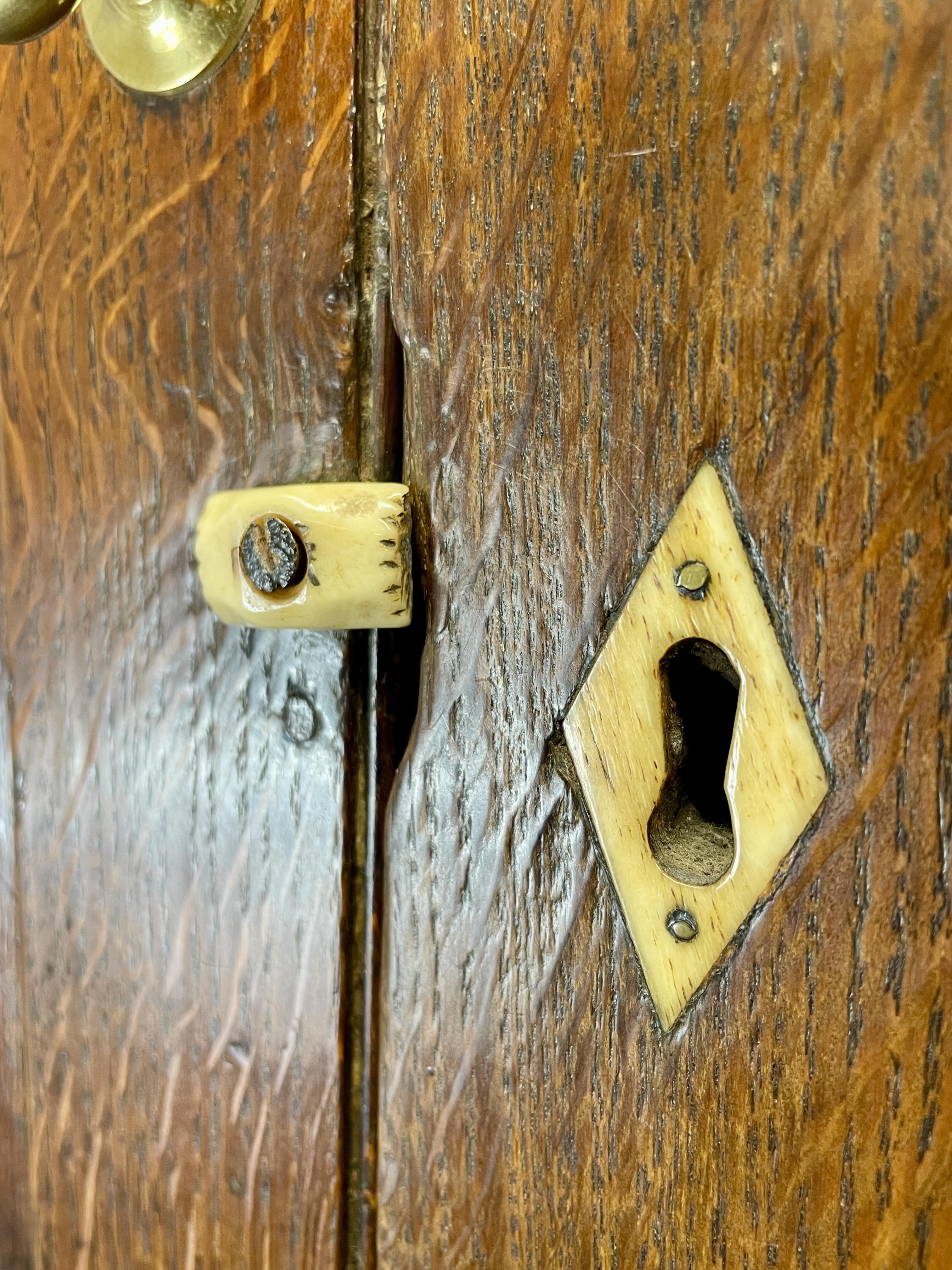 Close-up of a wooden door with a brass doorknob and keyhole.