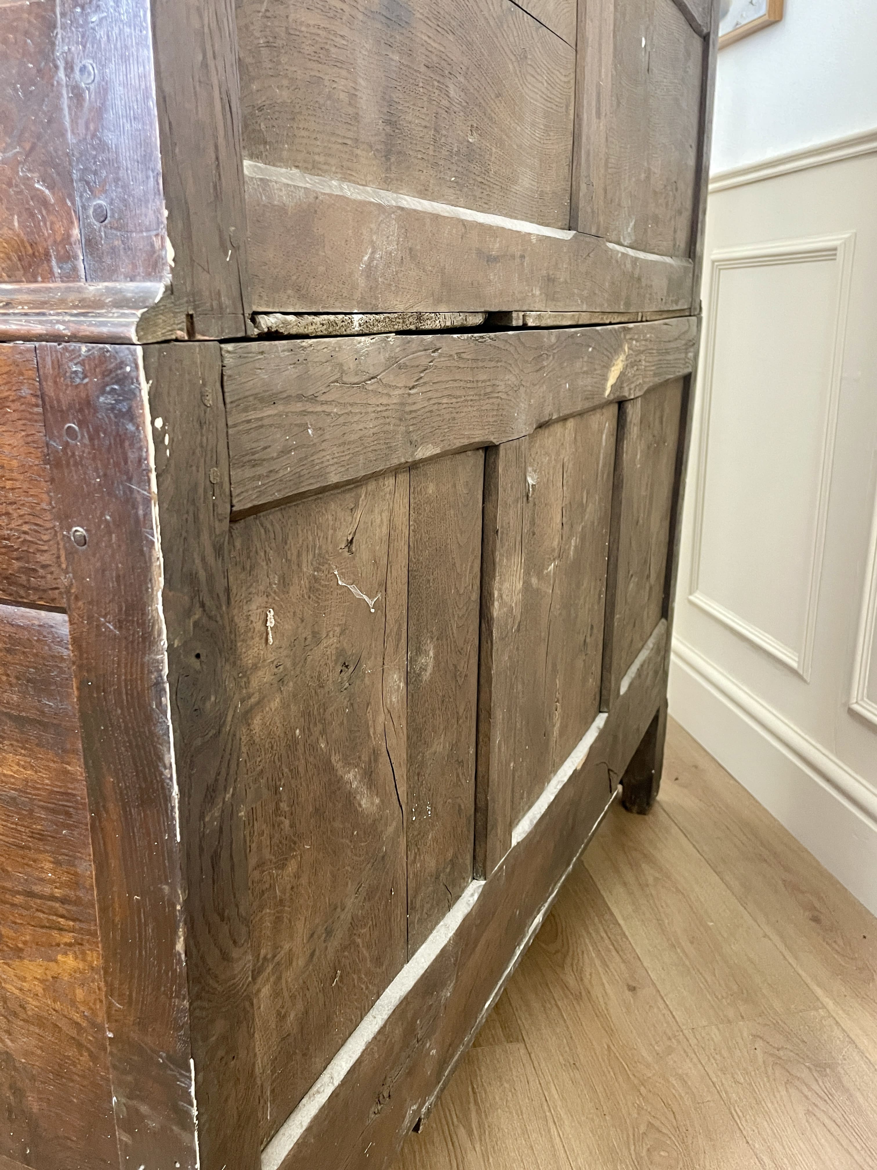Vintage wooden cabinet with a white baseboard in the background