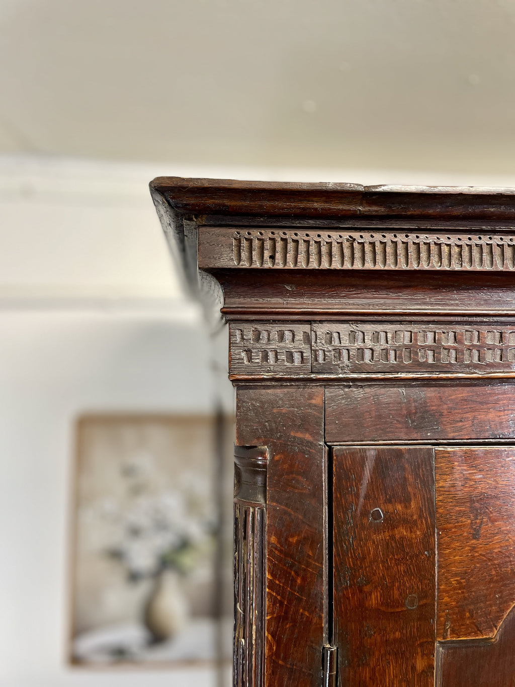 Wooden cabinet with intricate carvings on a white wall