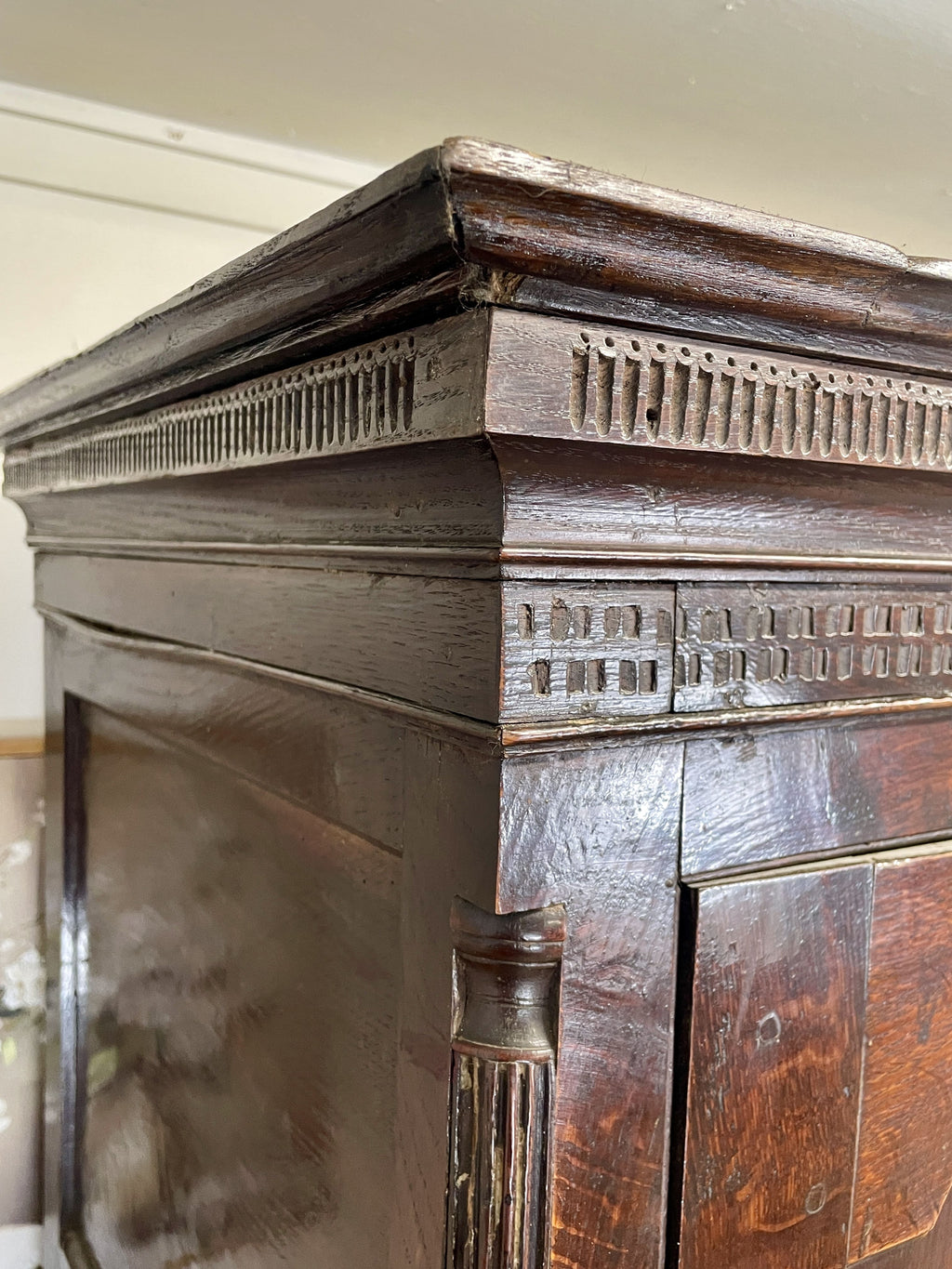 Close-up of a wooden fireplace mantel with intricate carvings.