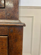 Close-up of an old wooden cabinet with a white wall background
