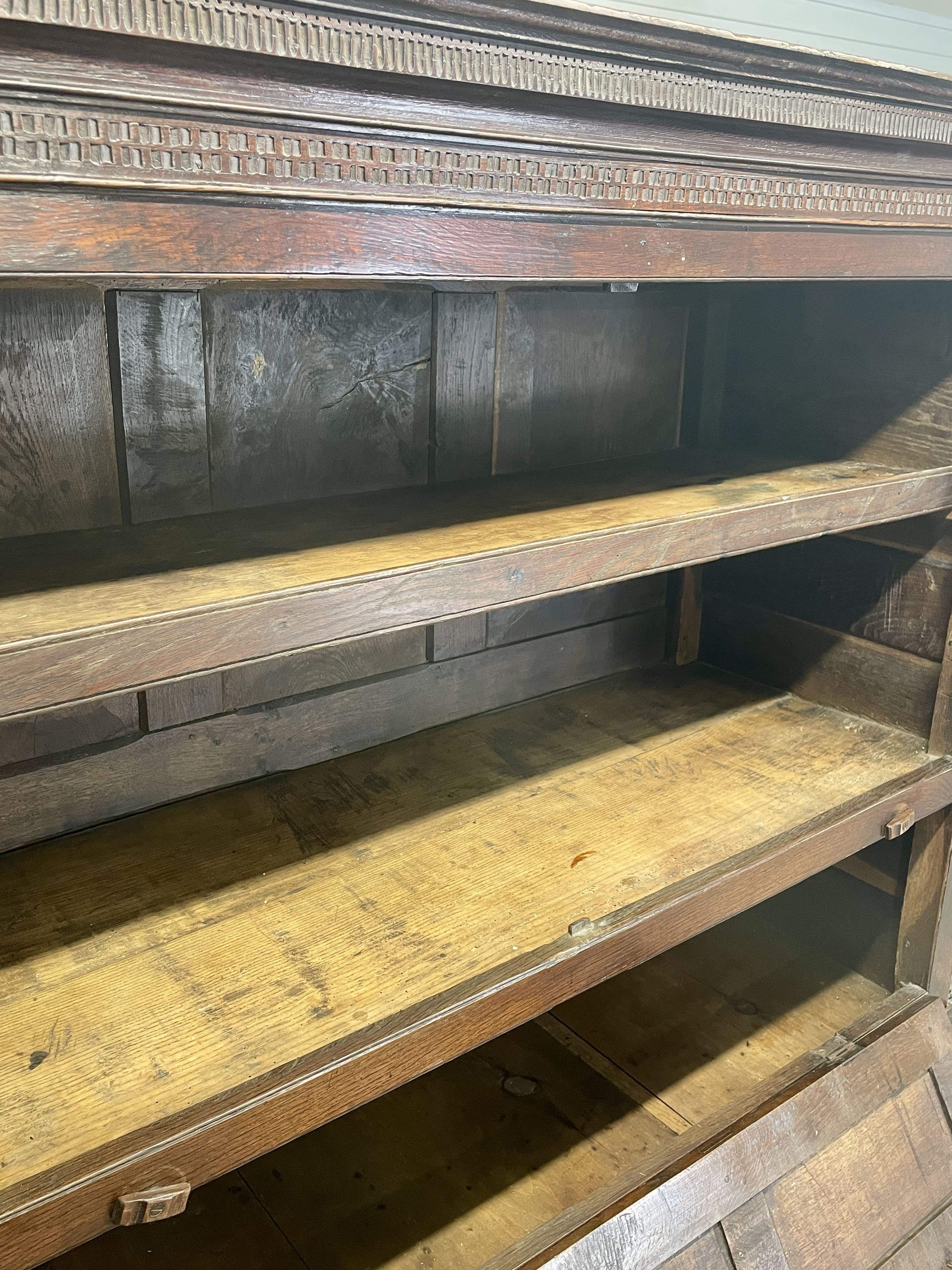 Wooden shelving unit with a decorative top shelf
