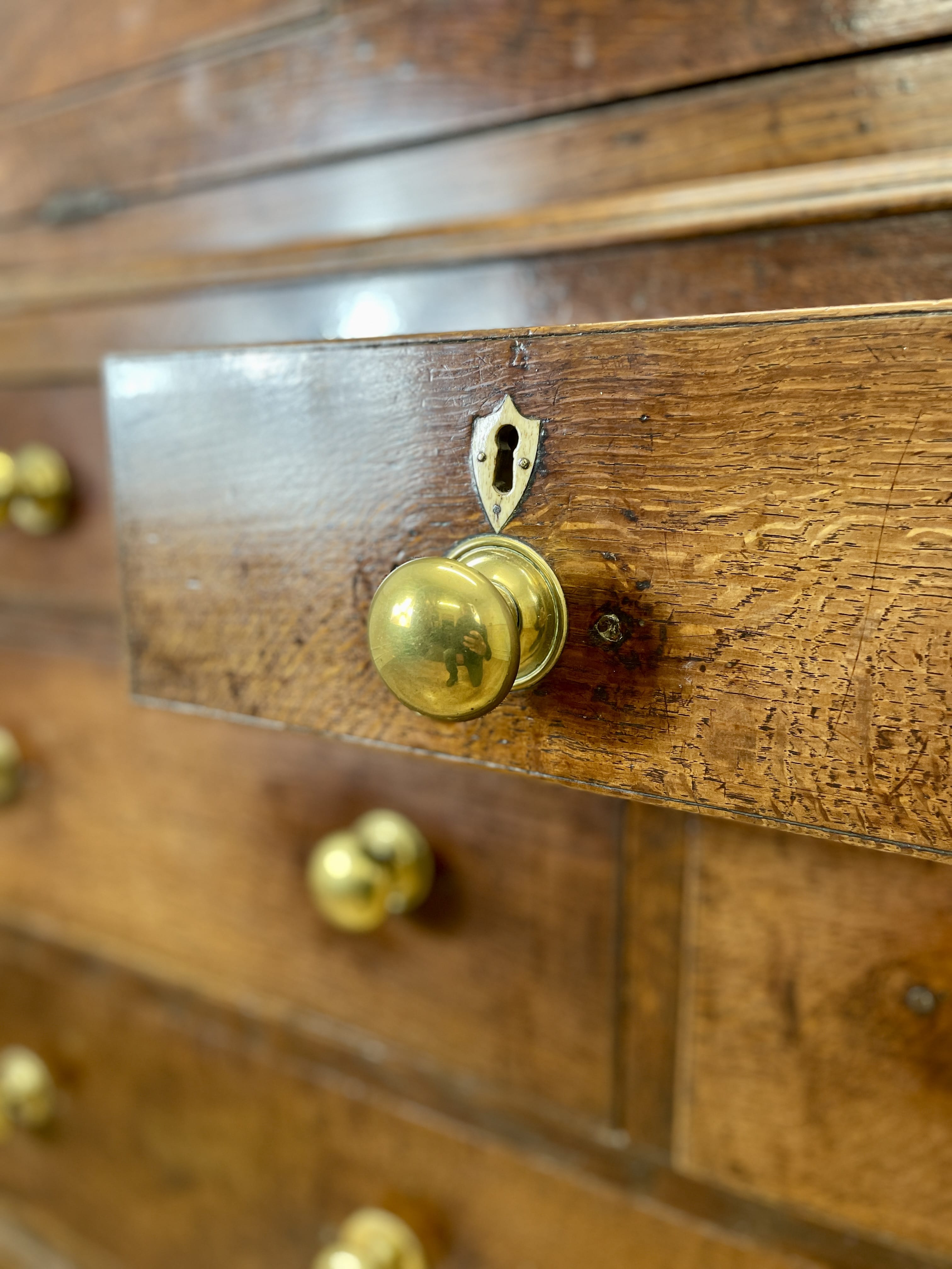 Close-up of a wooden drawer with brass handles and keyhole.