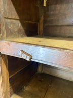 Old wooden cabinet with a drawer open, showing wear and tear.