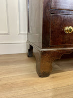 Wooden cabinet with a gold handle on a wooden floor.
