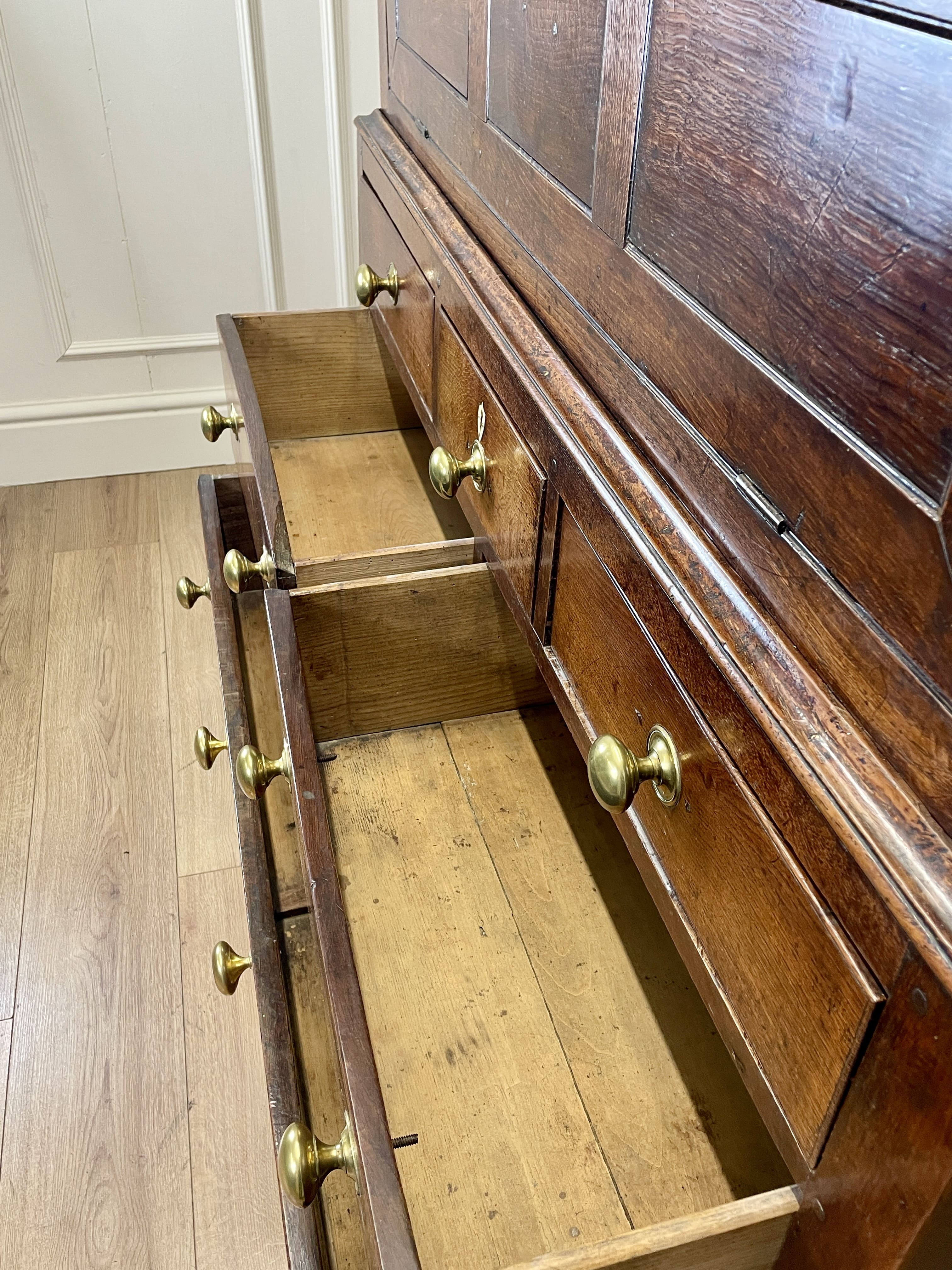 Wooden dresser with open drawer on a wooden floor