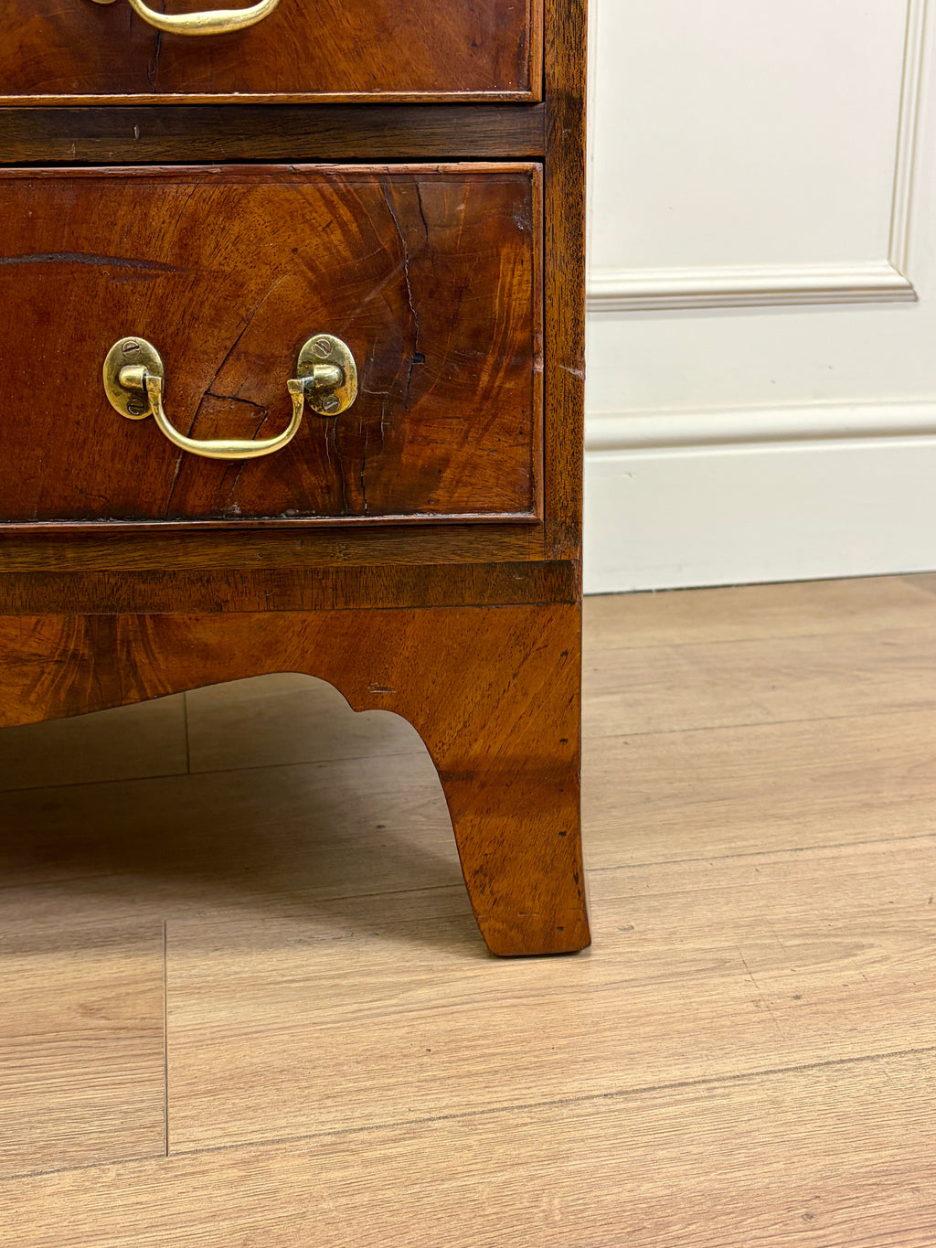 Wooden drawer with brass handle on a wooden floor