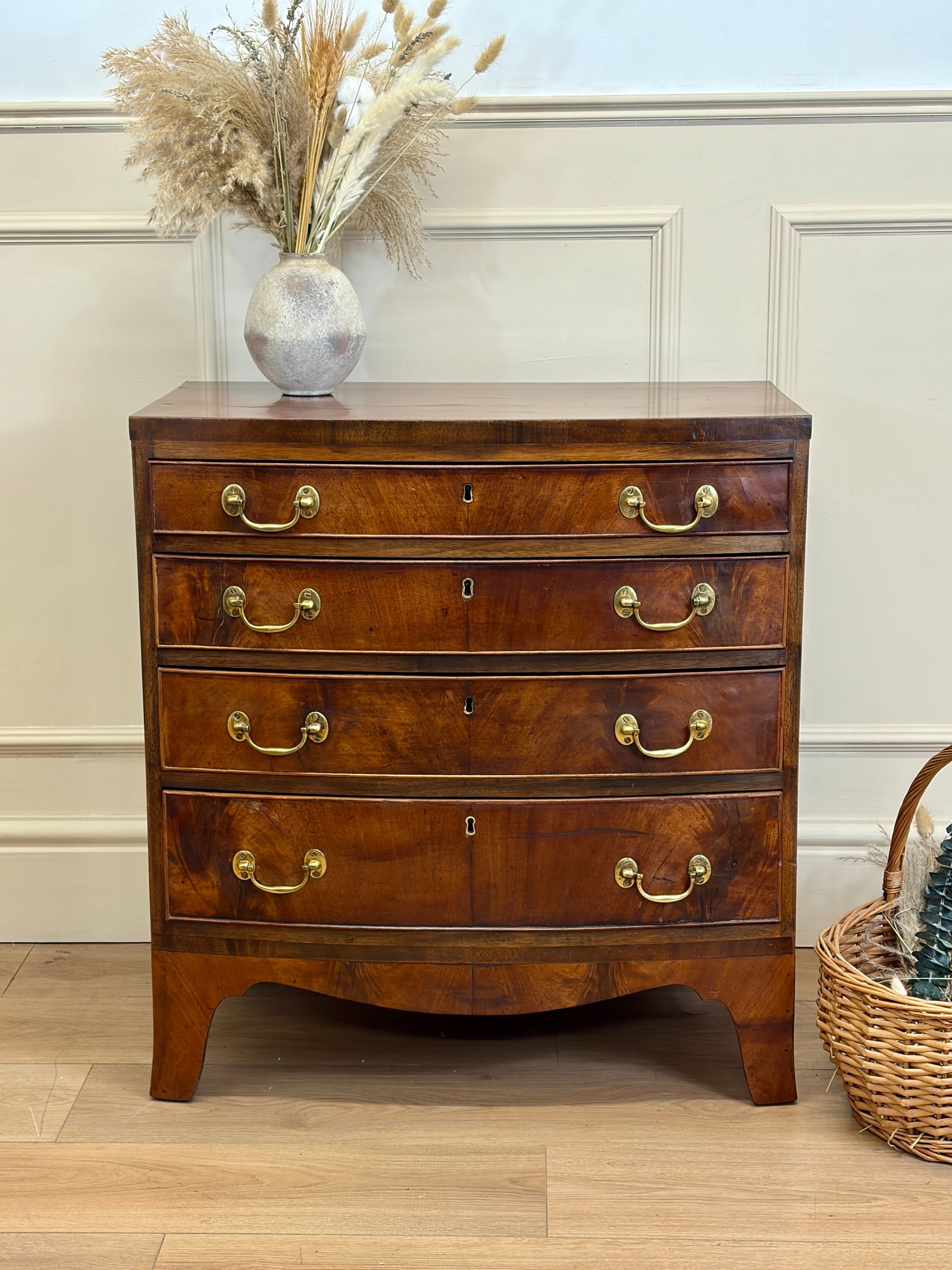 Wooden dresser with gold handles against a white wall