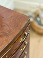 Wooden dresser with gold handles on a blurred background