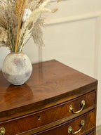 Vase with dried plants on a wooden dresser