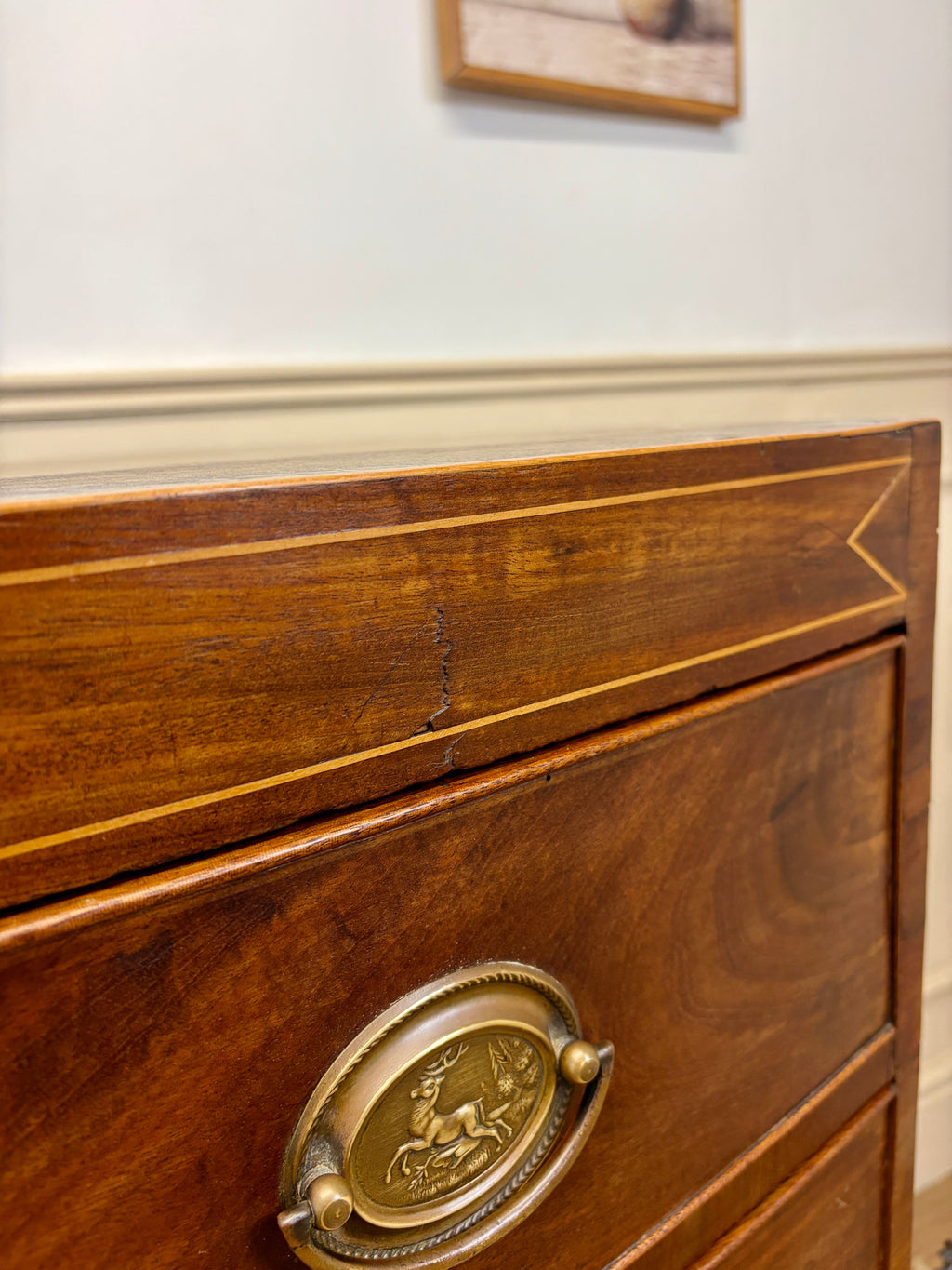 Wooden drawer with brass handle on a piece of furniture.