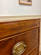 Wooden drawer with brass handle on a piece of furniture.