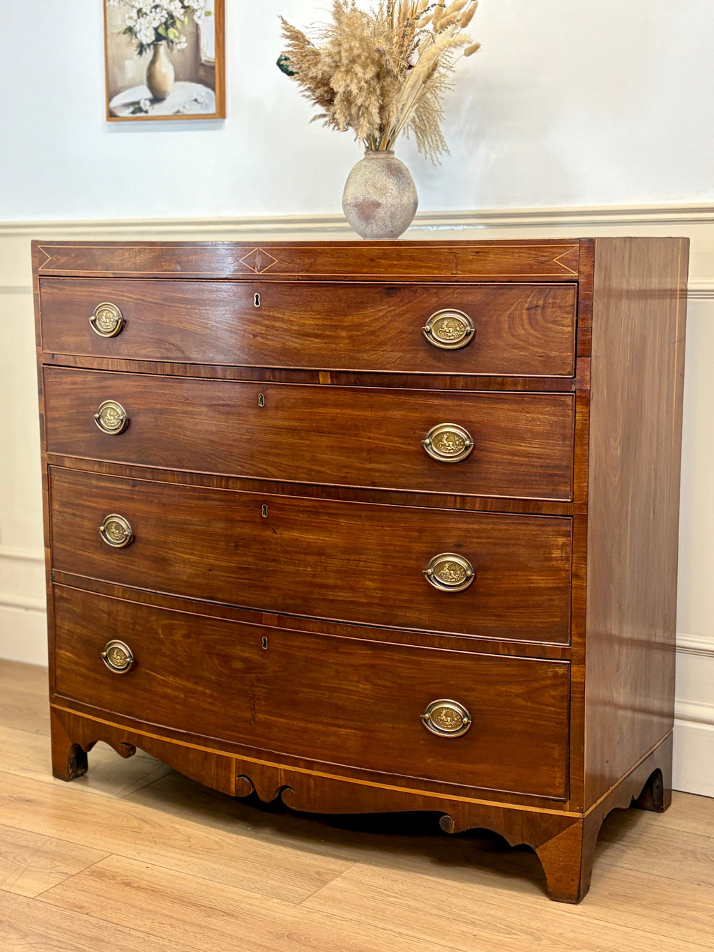 Wooden dresser with gold handles on a wooden floor.