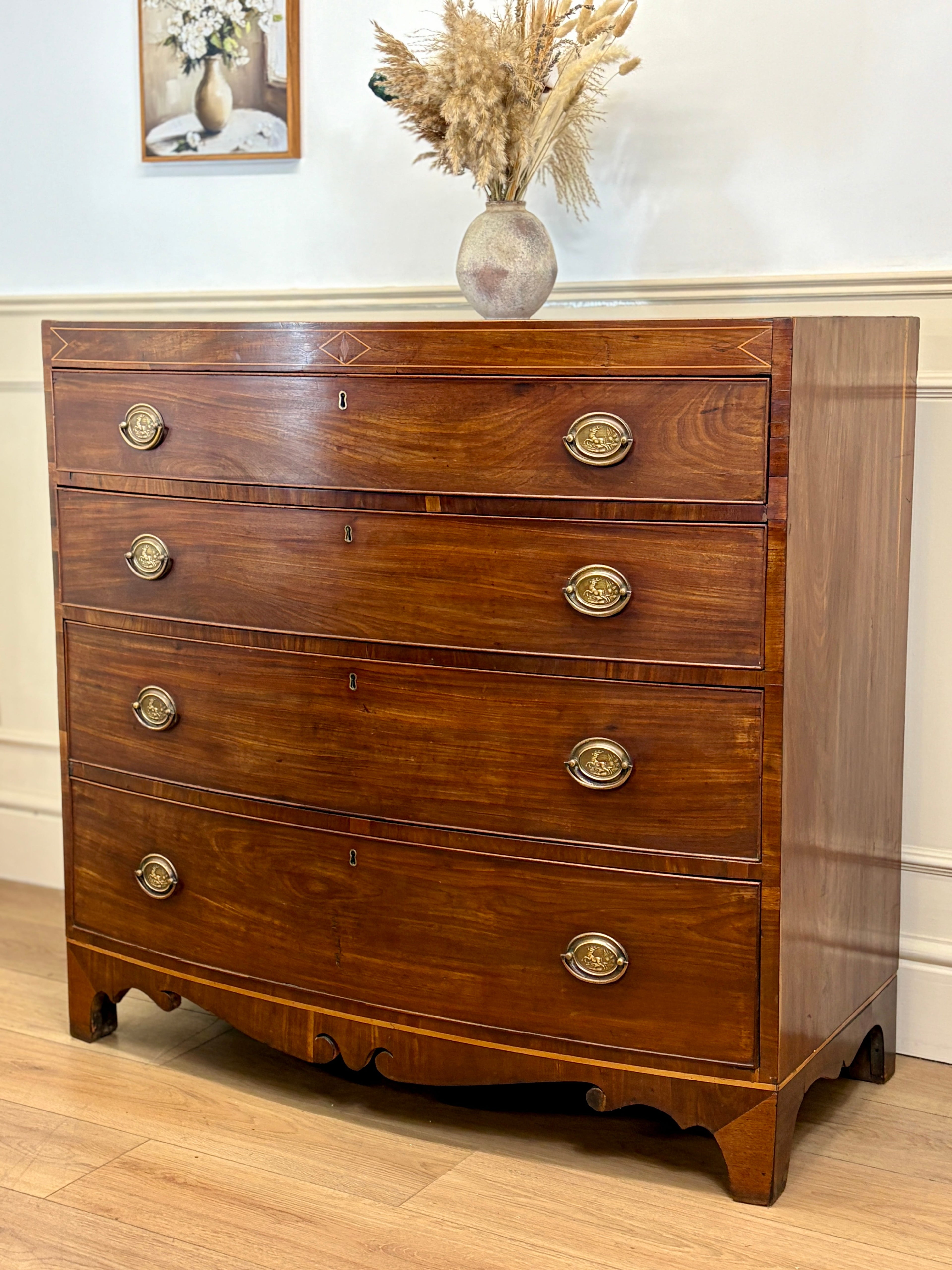 Wooden dresser with gold handles on a wooden floor.