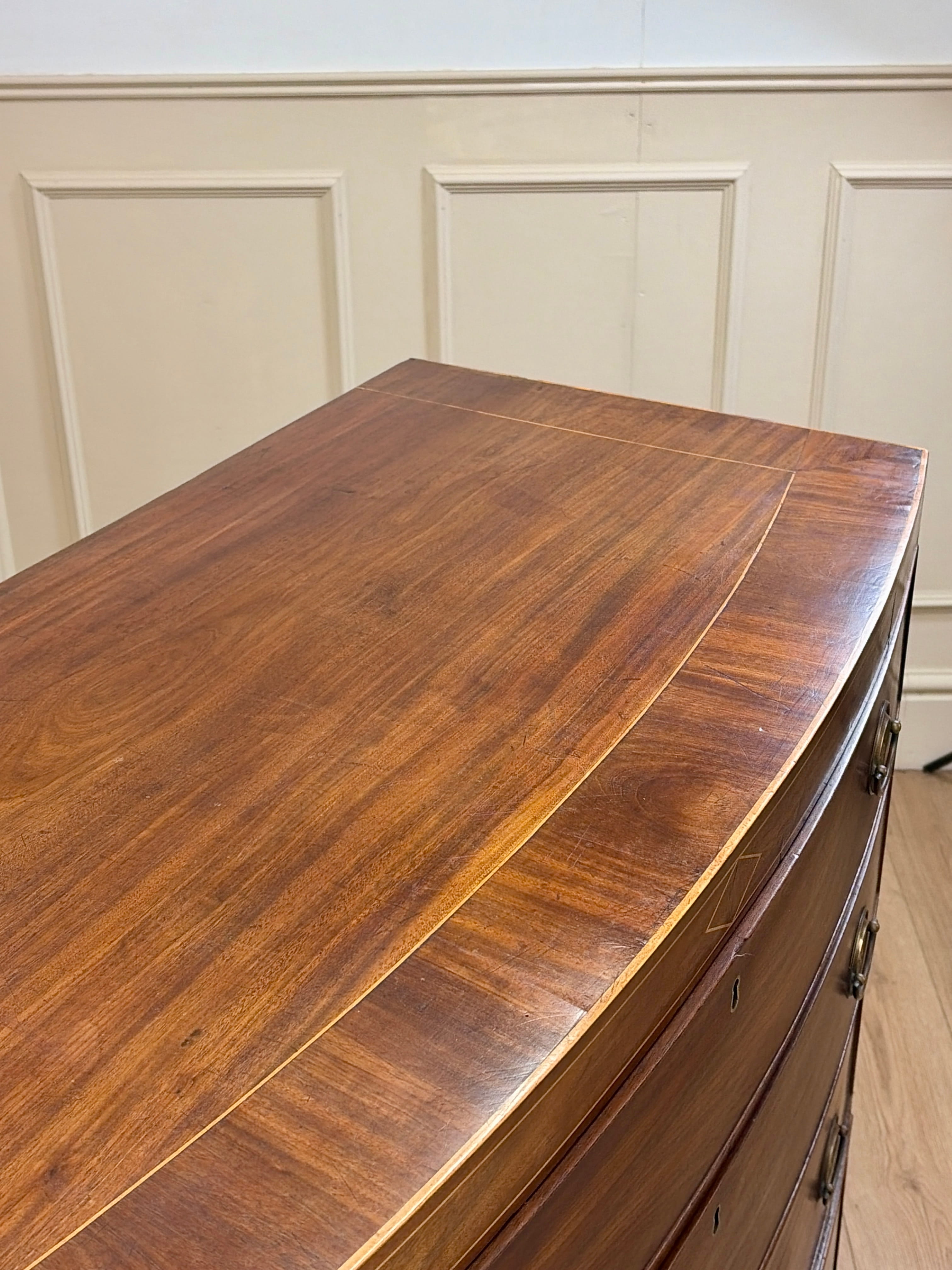 Wooden dresser with a smooth, polished surface against a neutral wall.