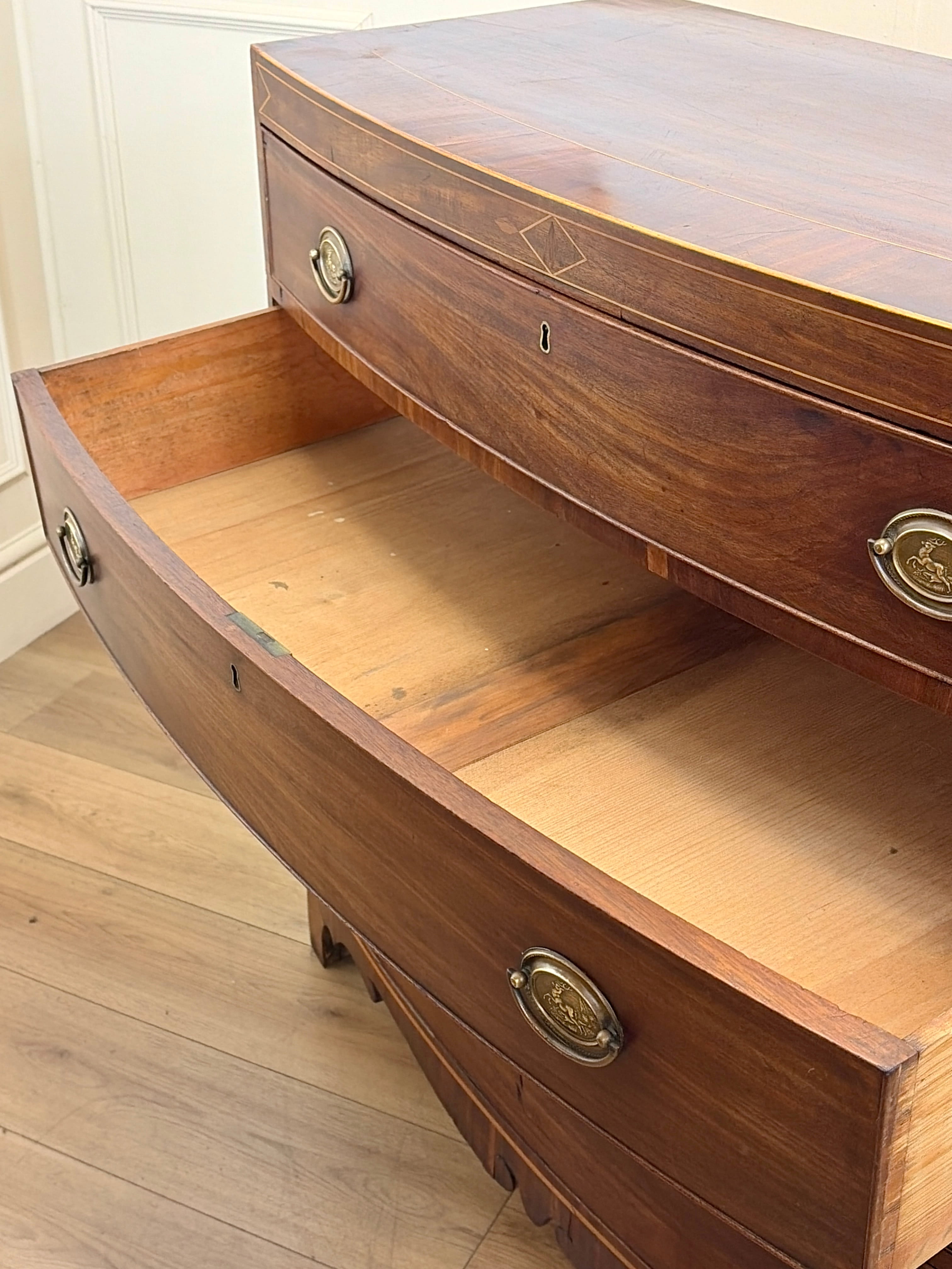 Wooden dresser with open drawer on a wooden floor