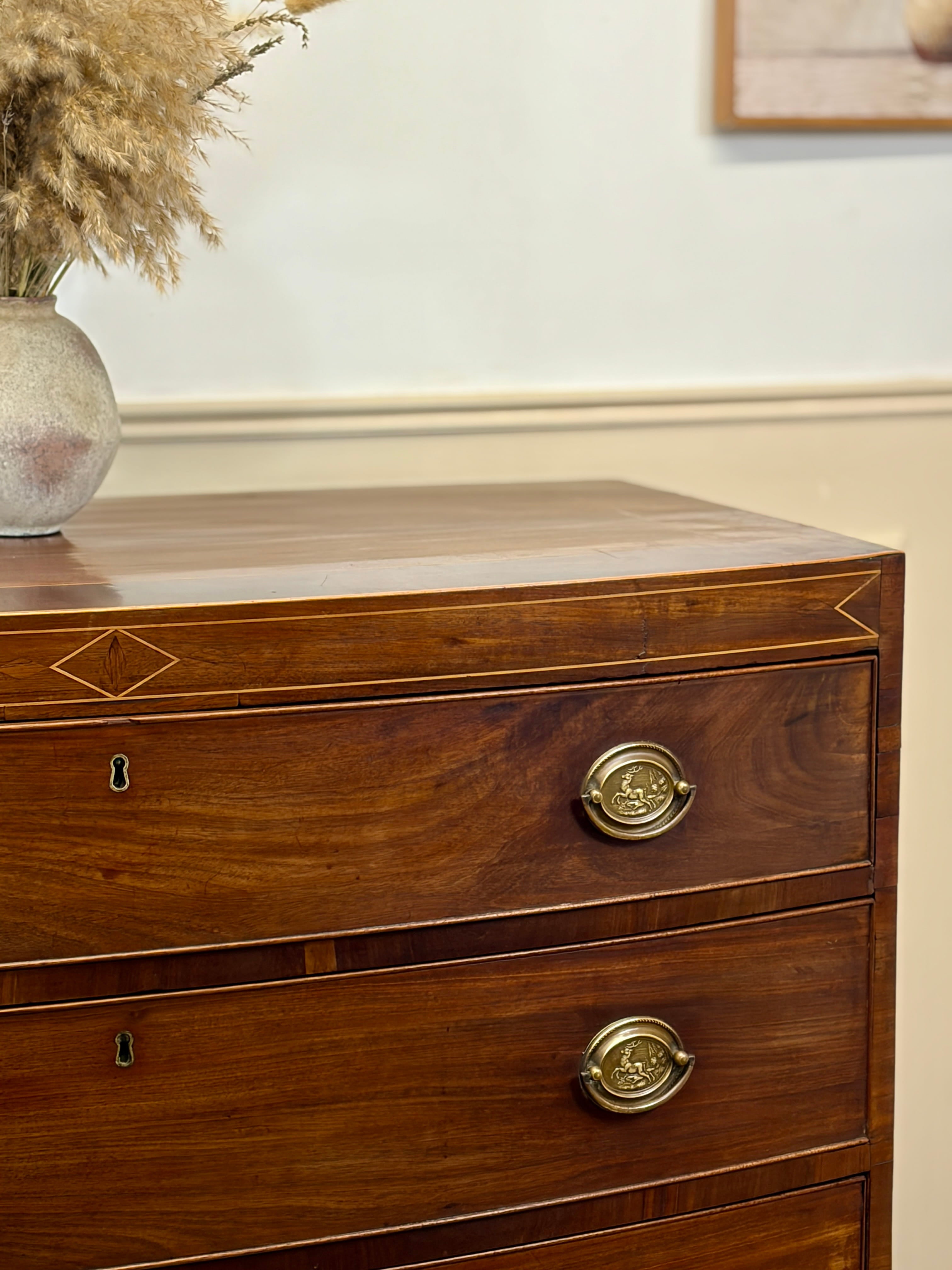 Wooden dresser with gold handles on a neutral background