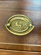 Brass decorative handle on a wooden surface