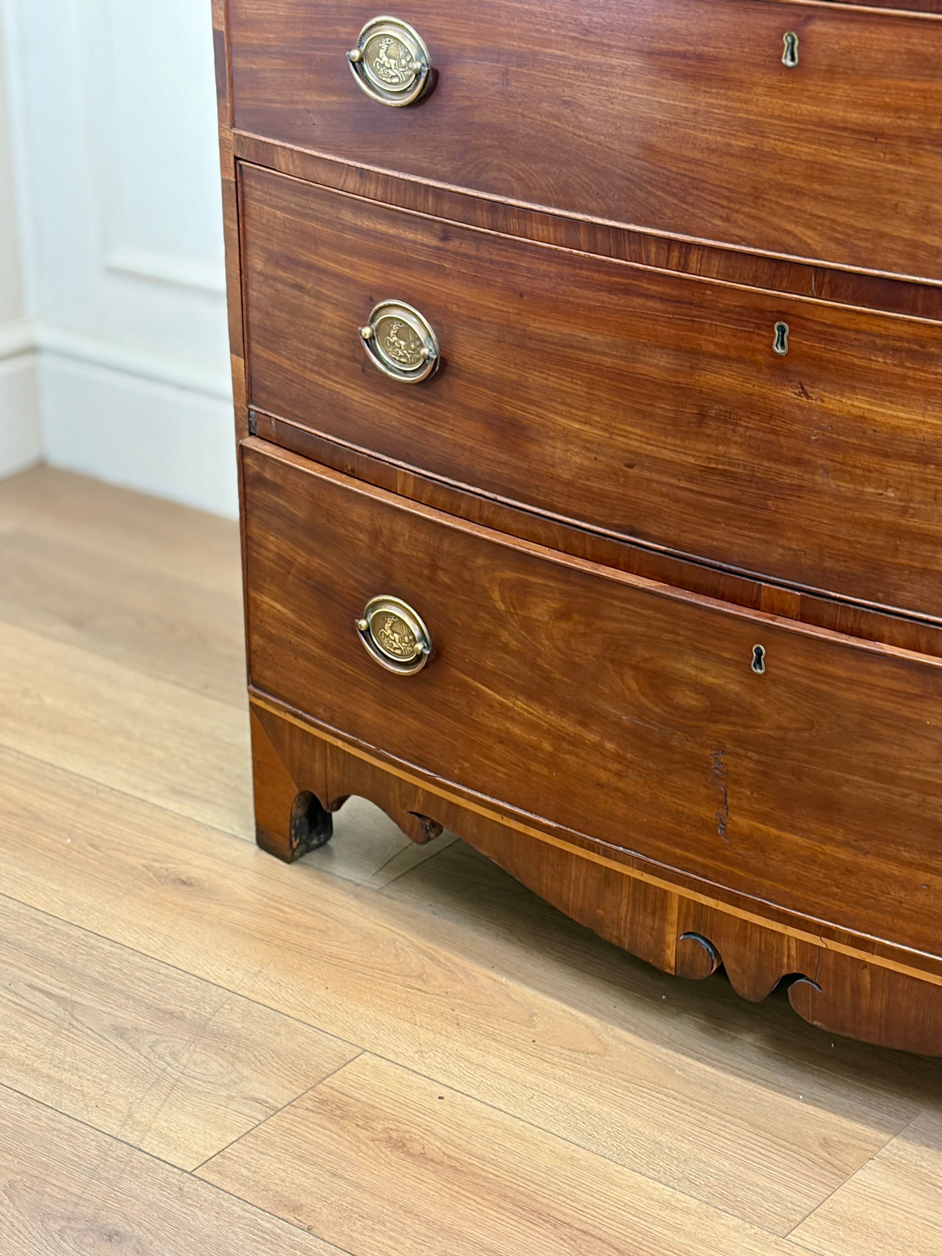Wooden dresser with brass handles on a wooden floor.