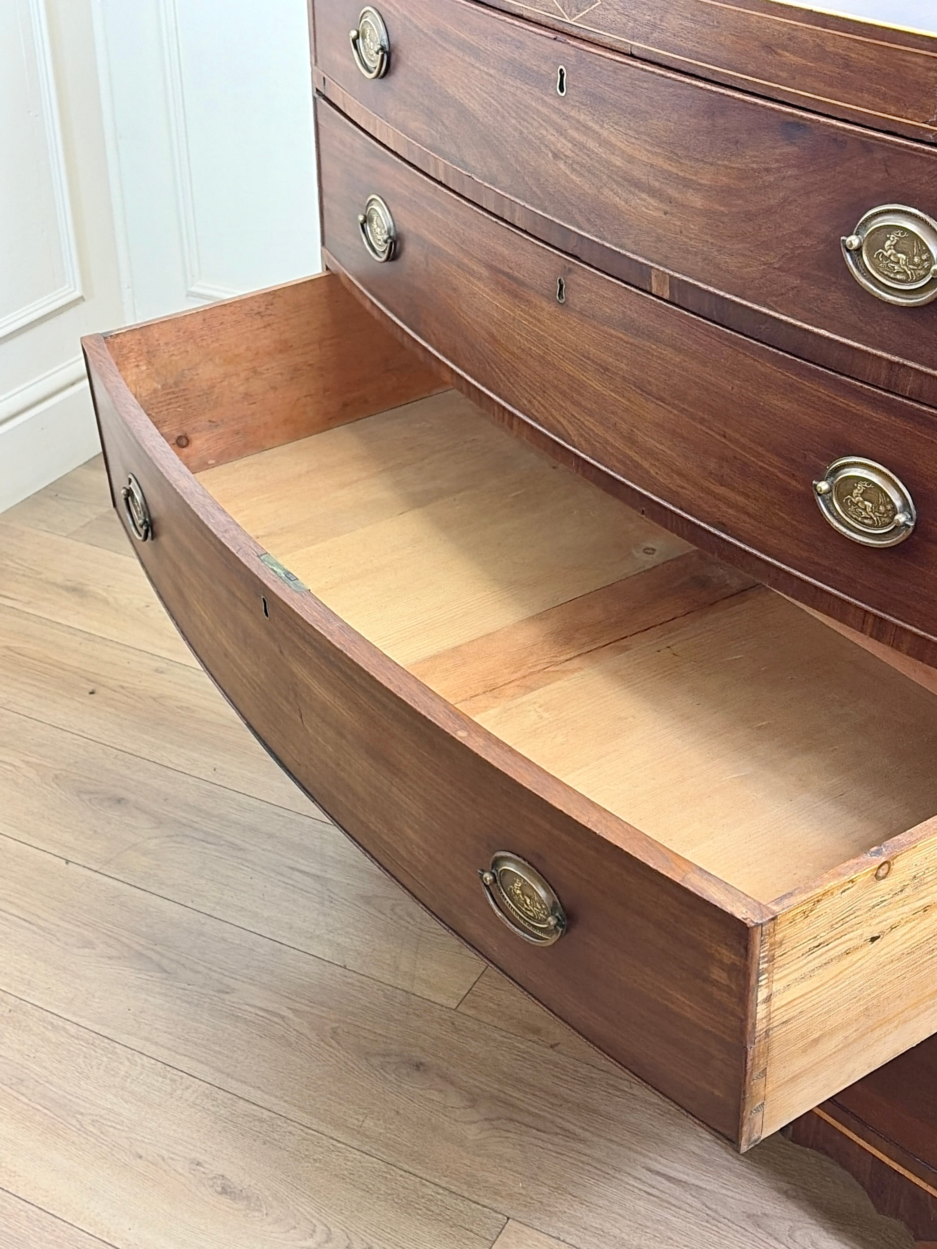 Wooden dresser with an open drawer on a wooden floor