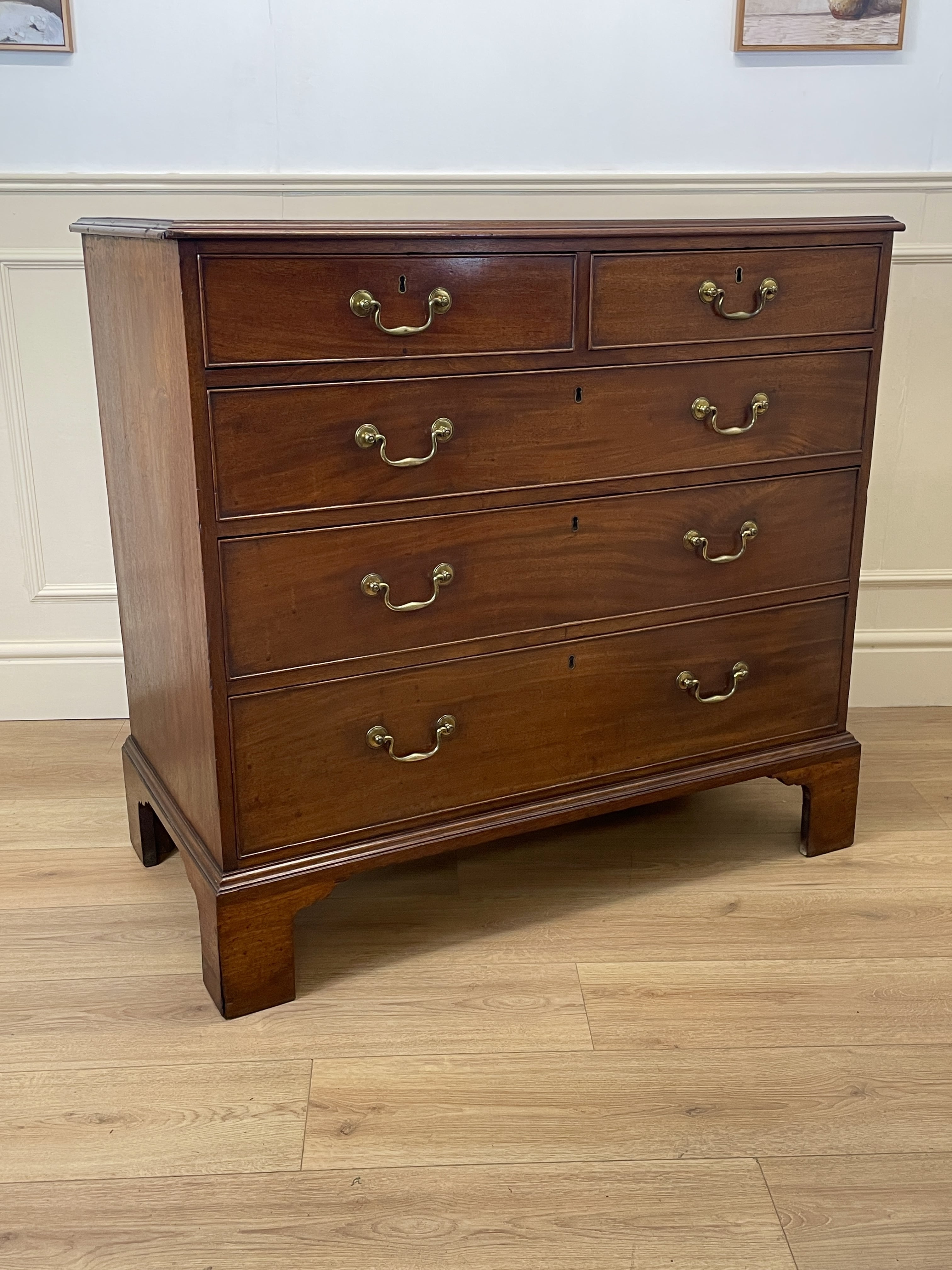 Antique Early Georgian mahogany straight front chest of drawers with original brass handles and flame mahogany finish, professionally restored by Taylors Antiques & Interiors.