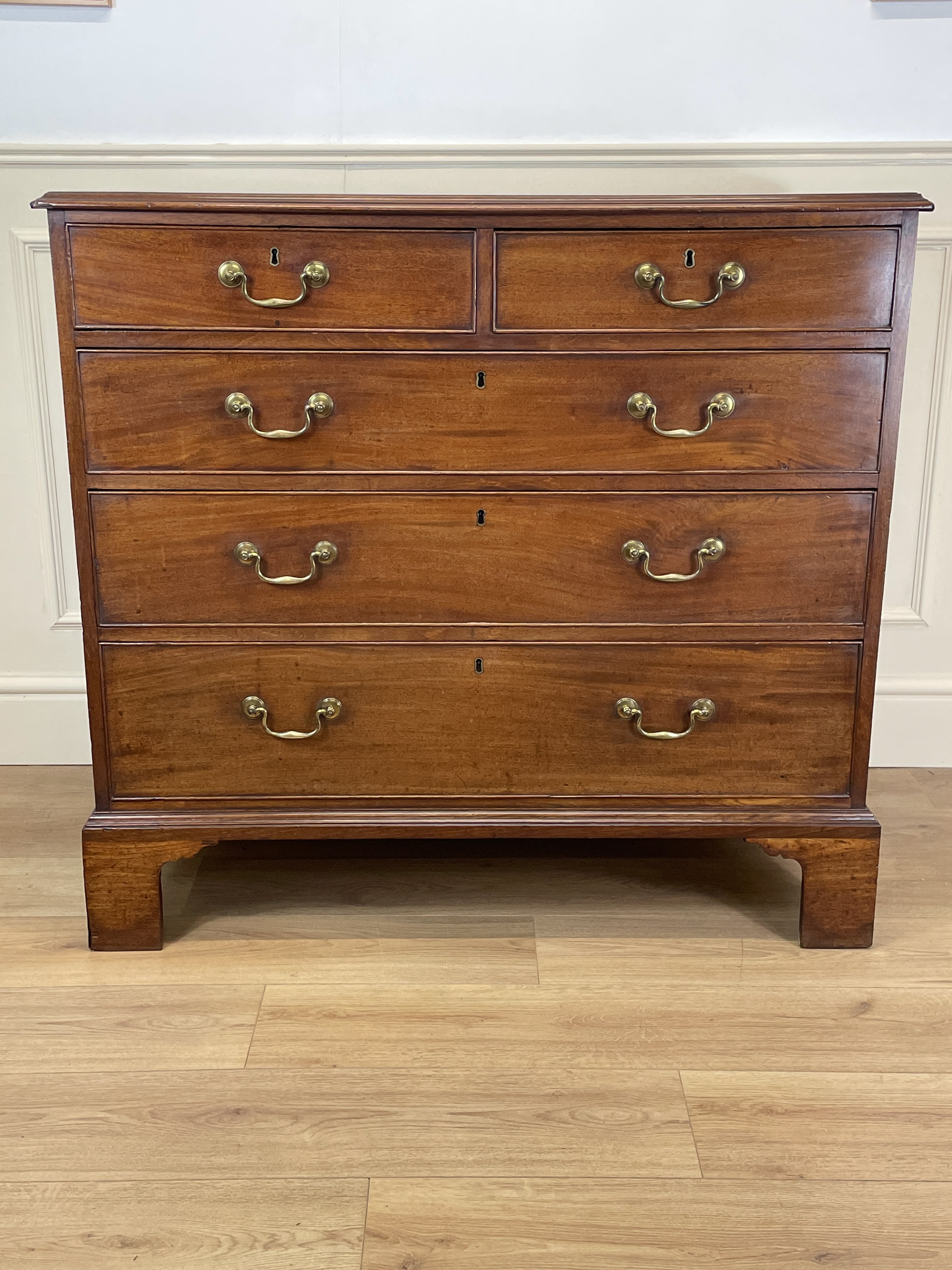 Antique Early Georgian mahogany straight front chest of drawers with original brass handles and flame mahogany finish, professionally restored by Taylors Antiques & Interiors.