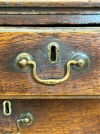 Close-up of a wooden drawer with brass handles and keyhole.