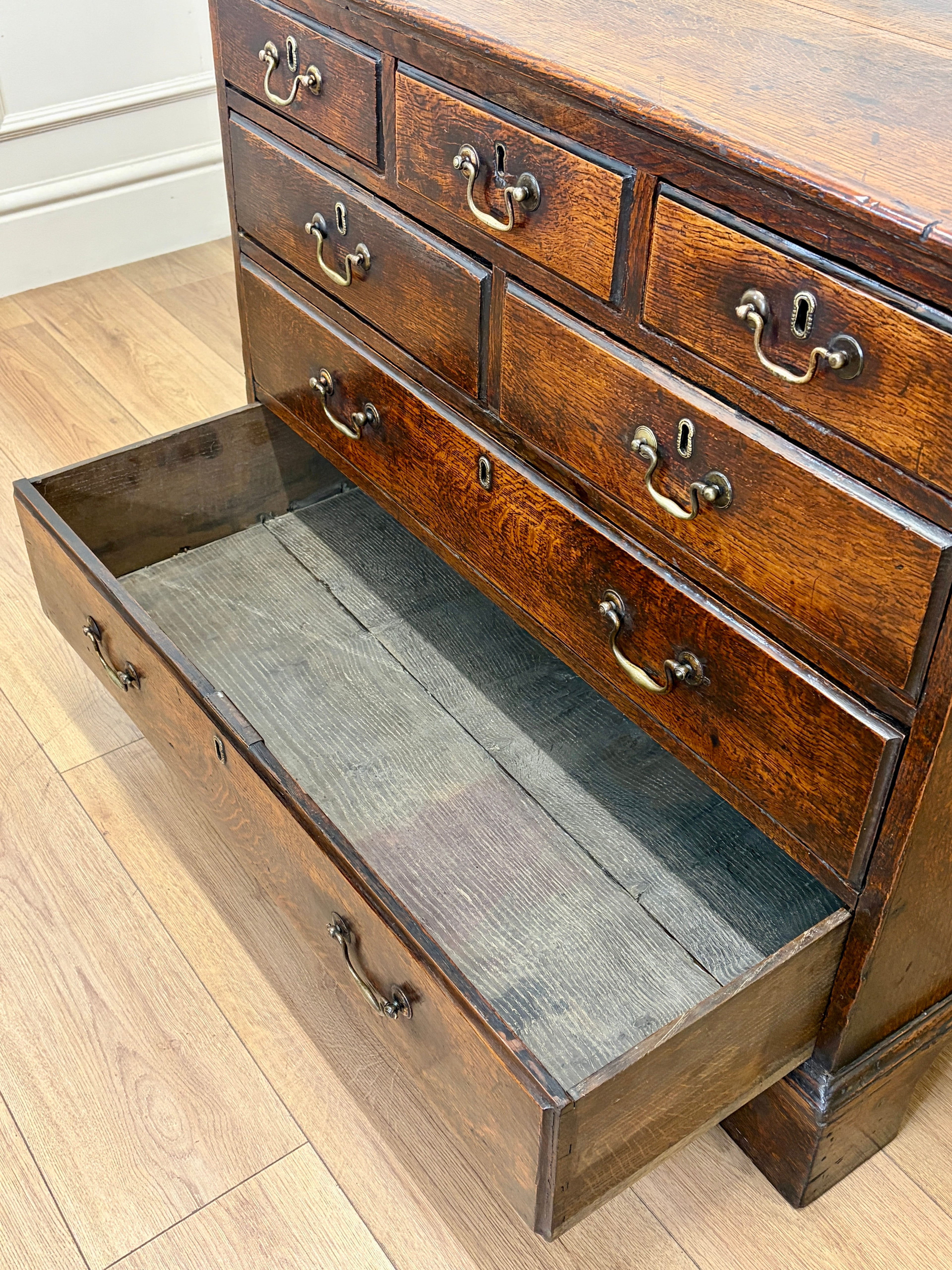 Wooden dresser with open drawer on a wooden floor