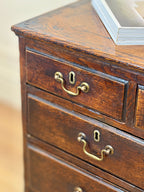 Close-up of a wooden dresser with brass handles and keyholes.