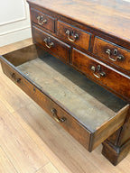 Wooden dresser with open drawer on a wooden floor