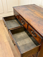 Wooden desk with open drawers on a wooden floor.