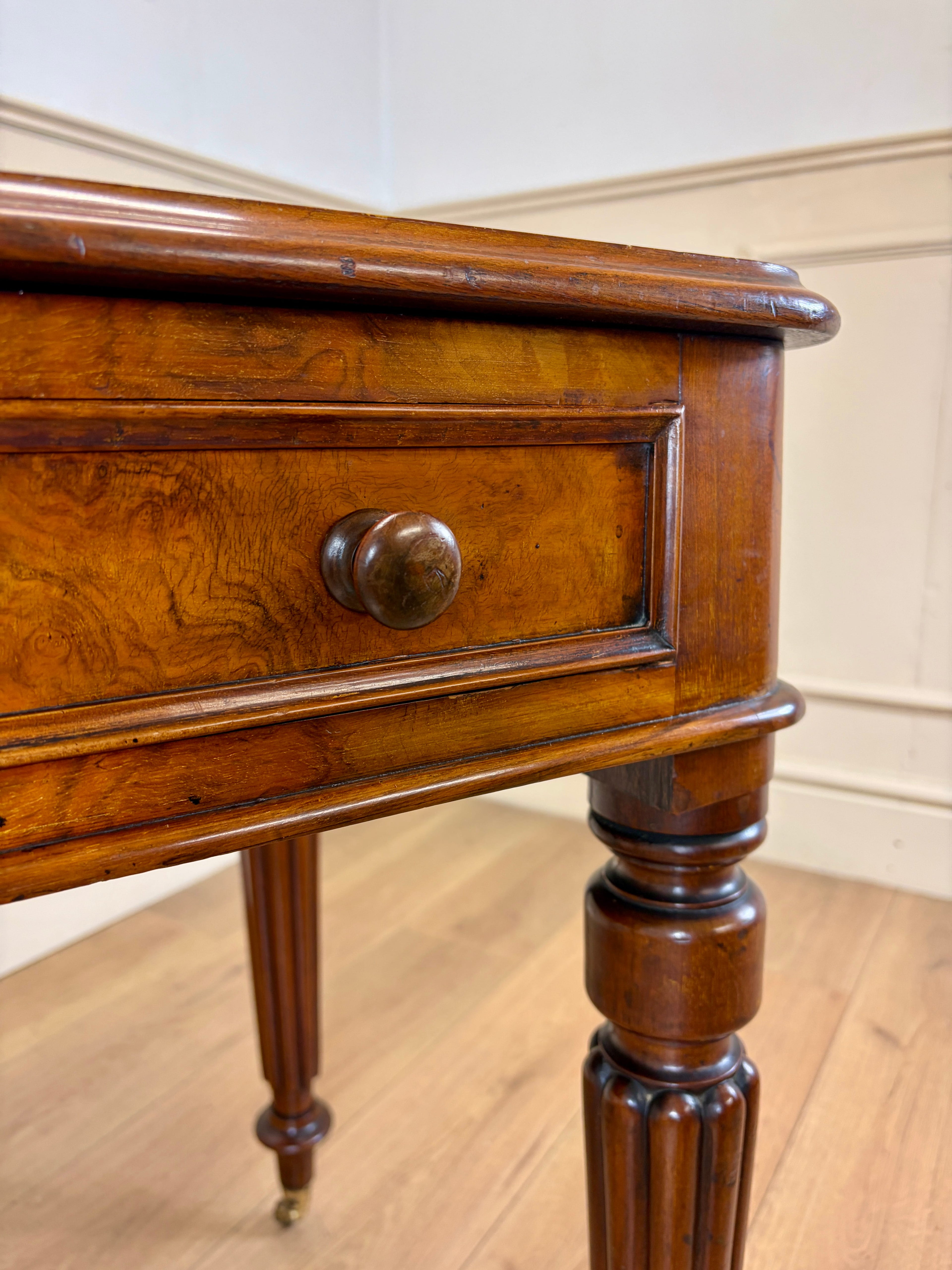 Close-up of a wooden drawer with a knob on a wooden floor.
