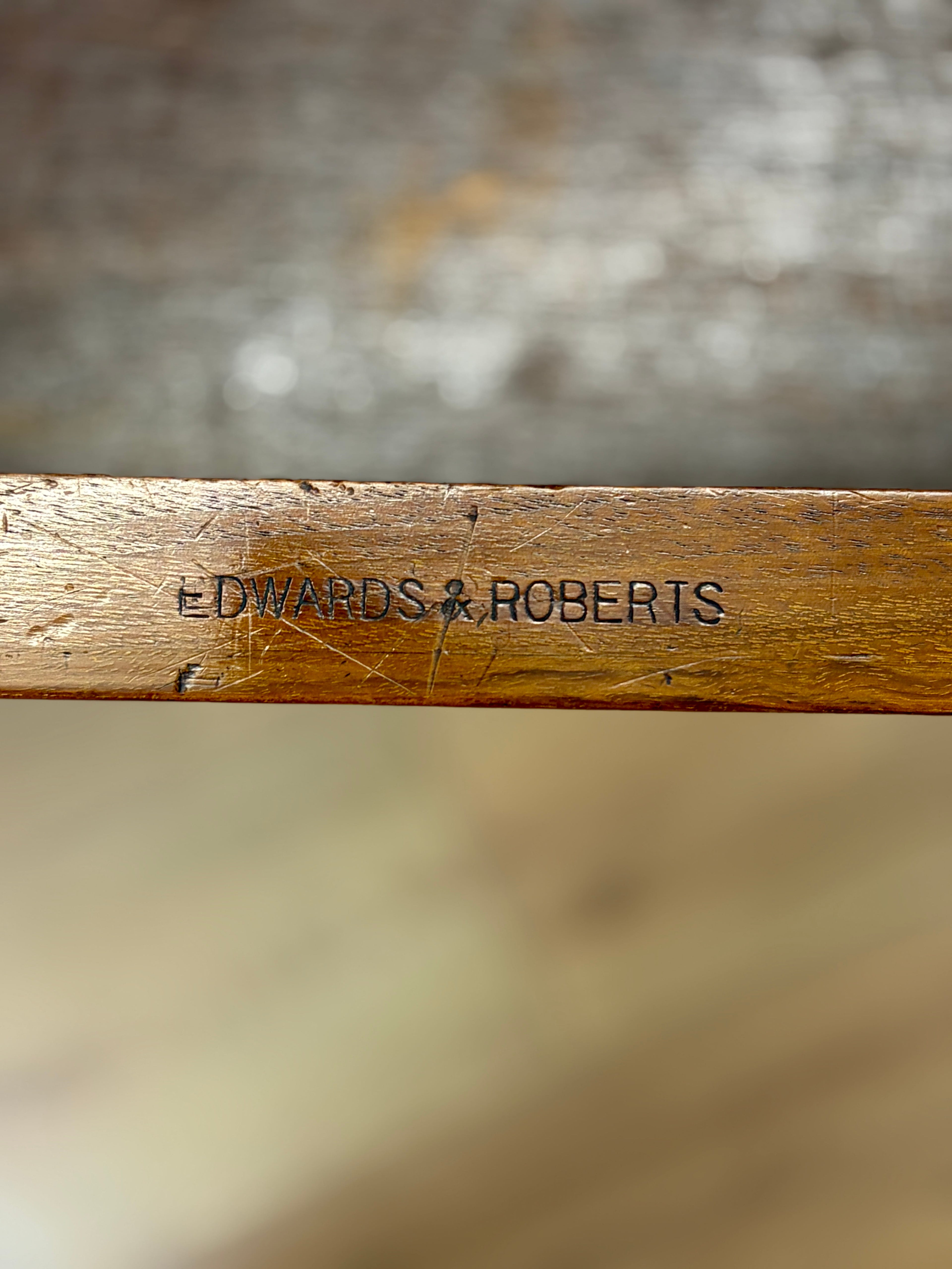 Wooden object with 'Edwards & Roberts' engraving on a blurred background
