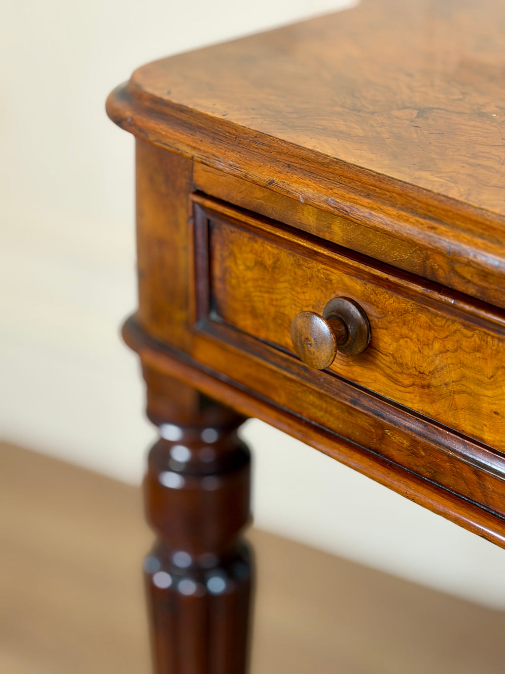 Close-up of a wooden side table with a drawer.