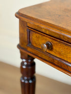 Close-up of a wooden side table with a drawer.