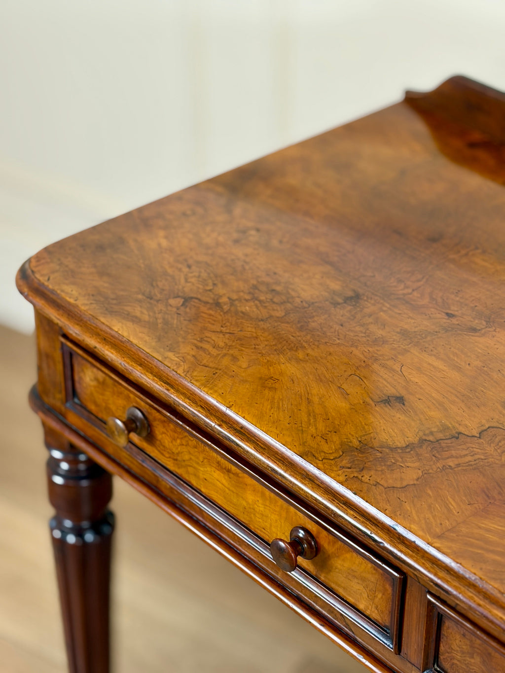 Wooden side table with a single drawer on a neutral background