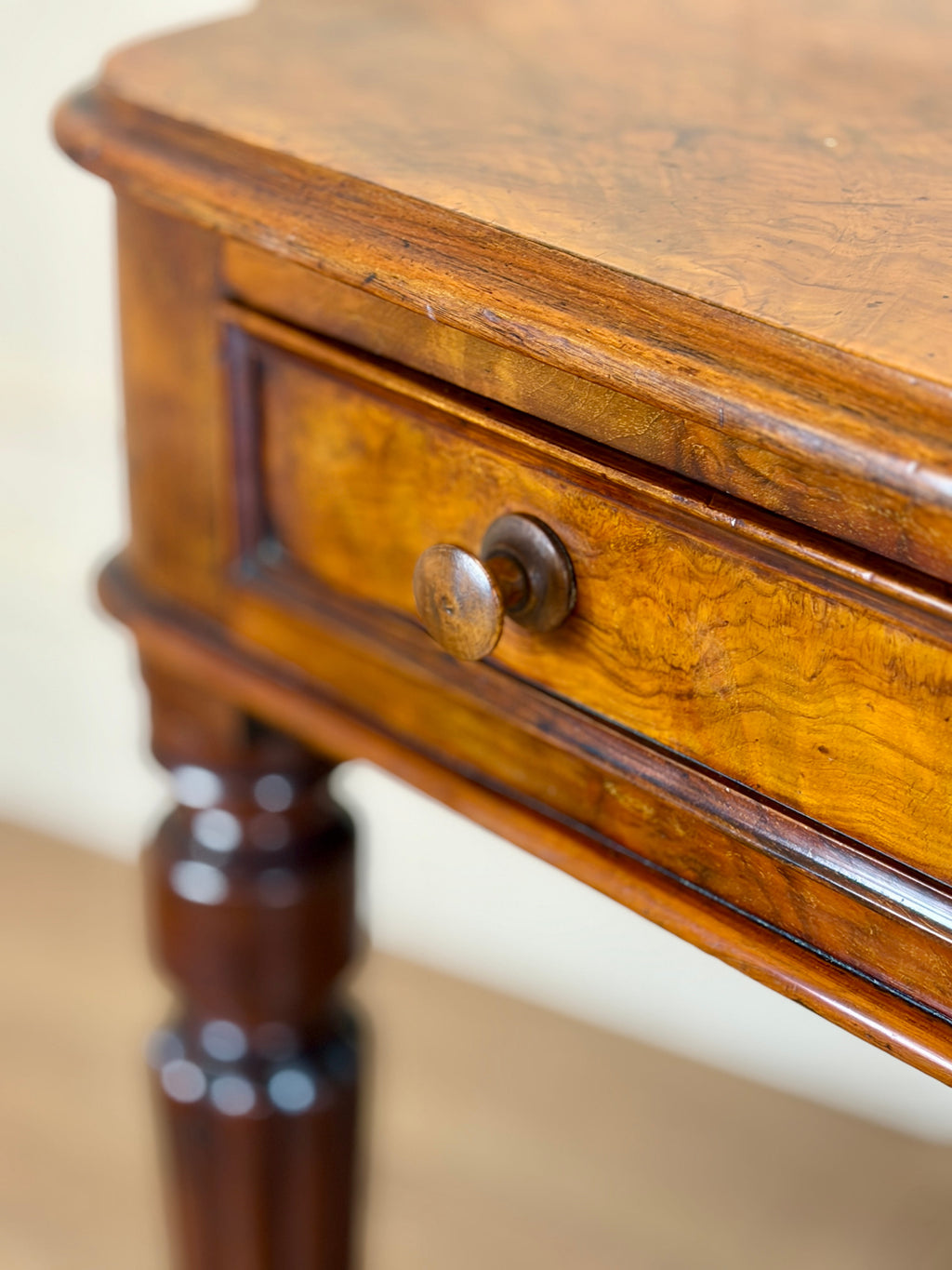 Close-up of a wooden side table with a drawer.