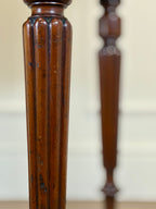 Close-up of a wooden spindle with intricate carvings on a plain background