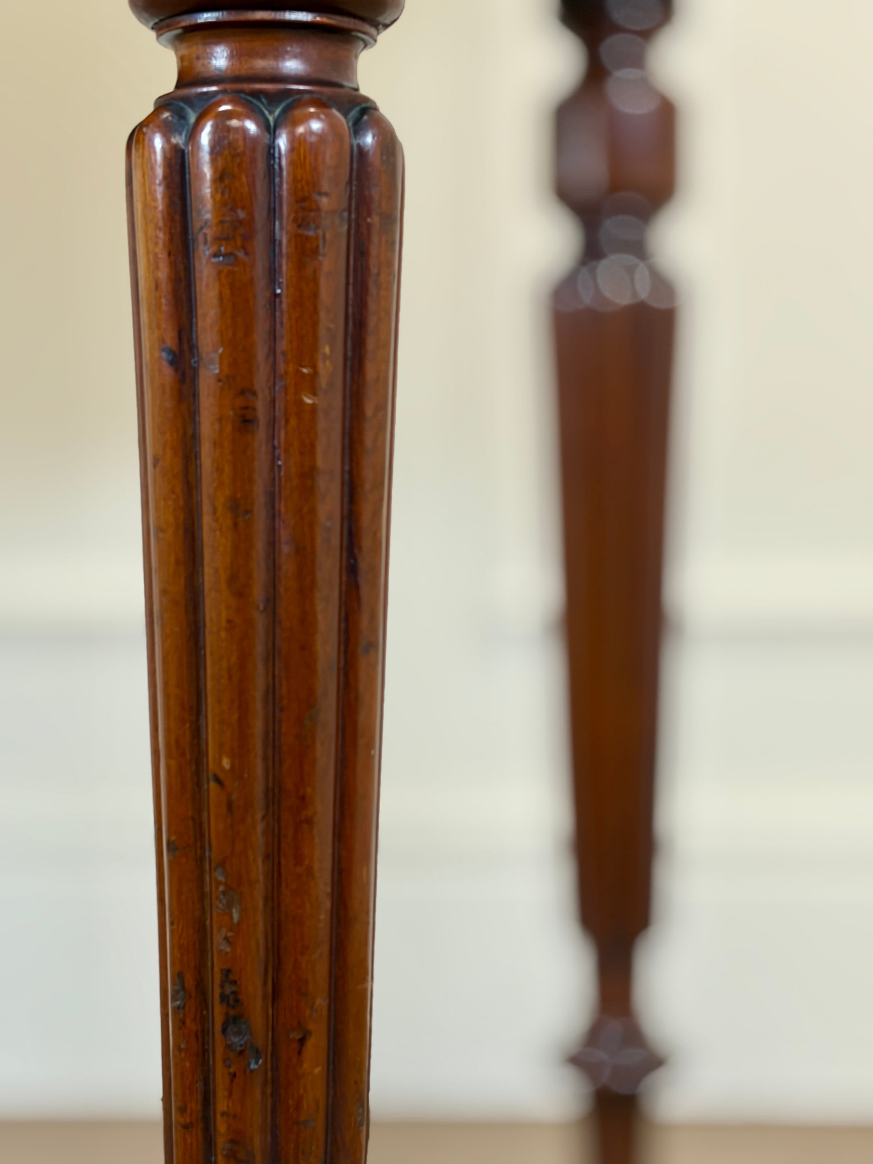Close-up of a wooden spindle with intricate carvings on a plain background