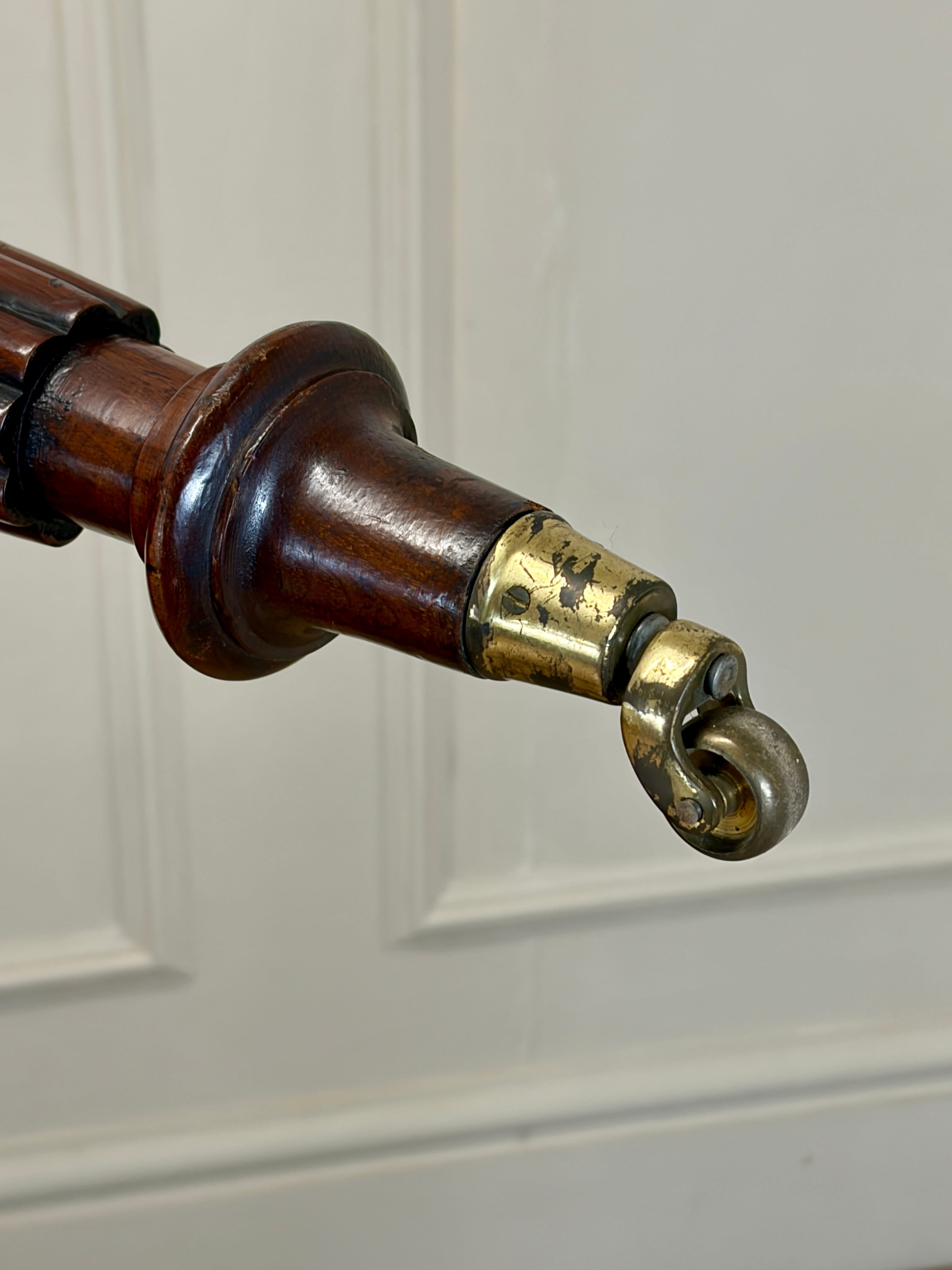 Close-up of a wooden and brass door handle on a white paneled door.